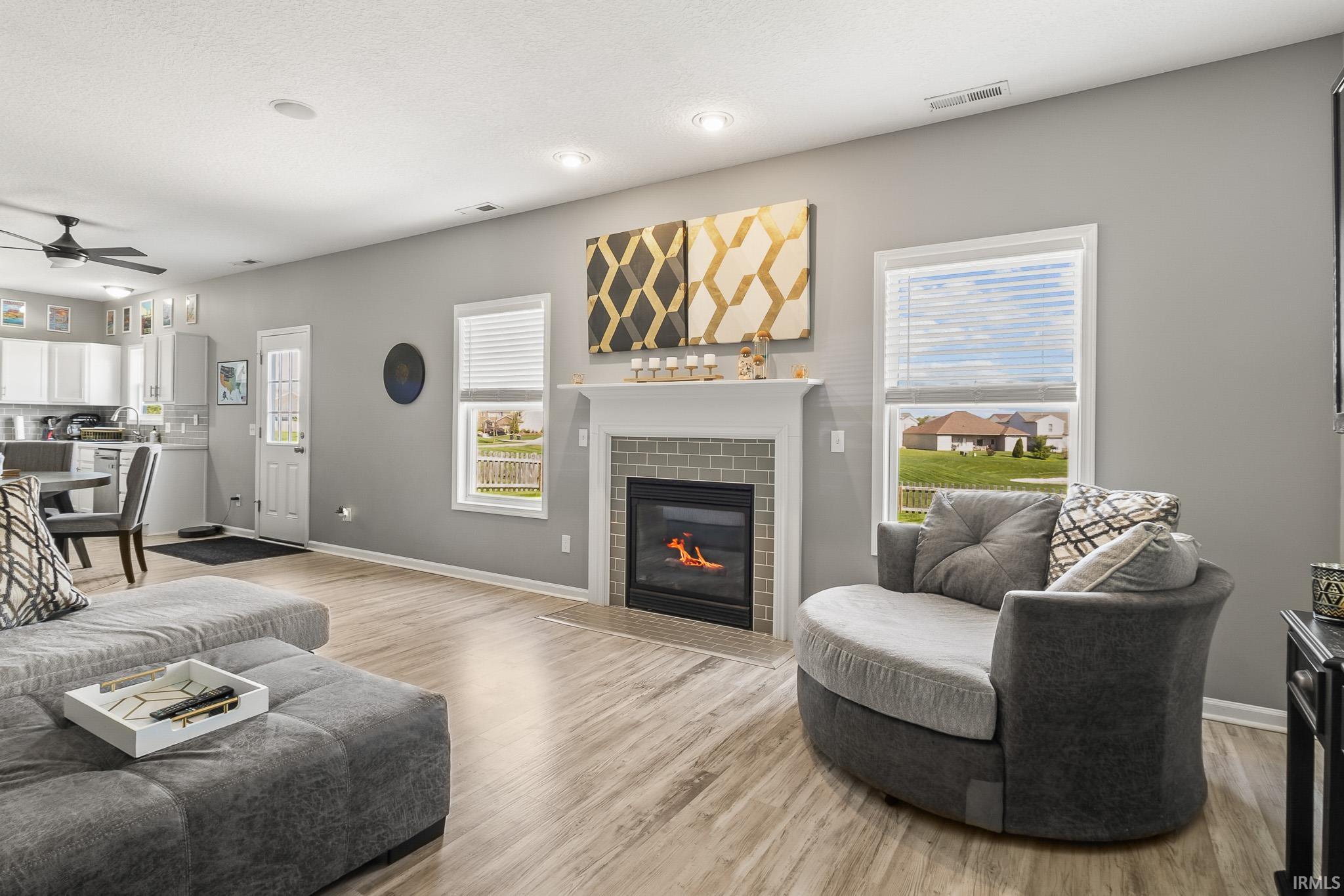 Living area featuring a central fireplace with light gray subway tile surround and a classic white mantel