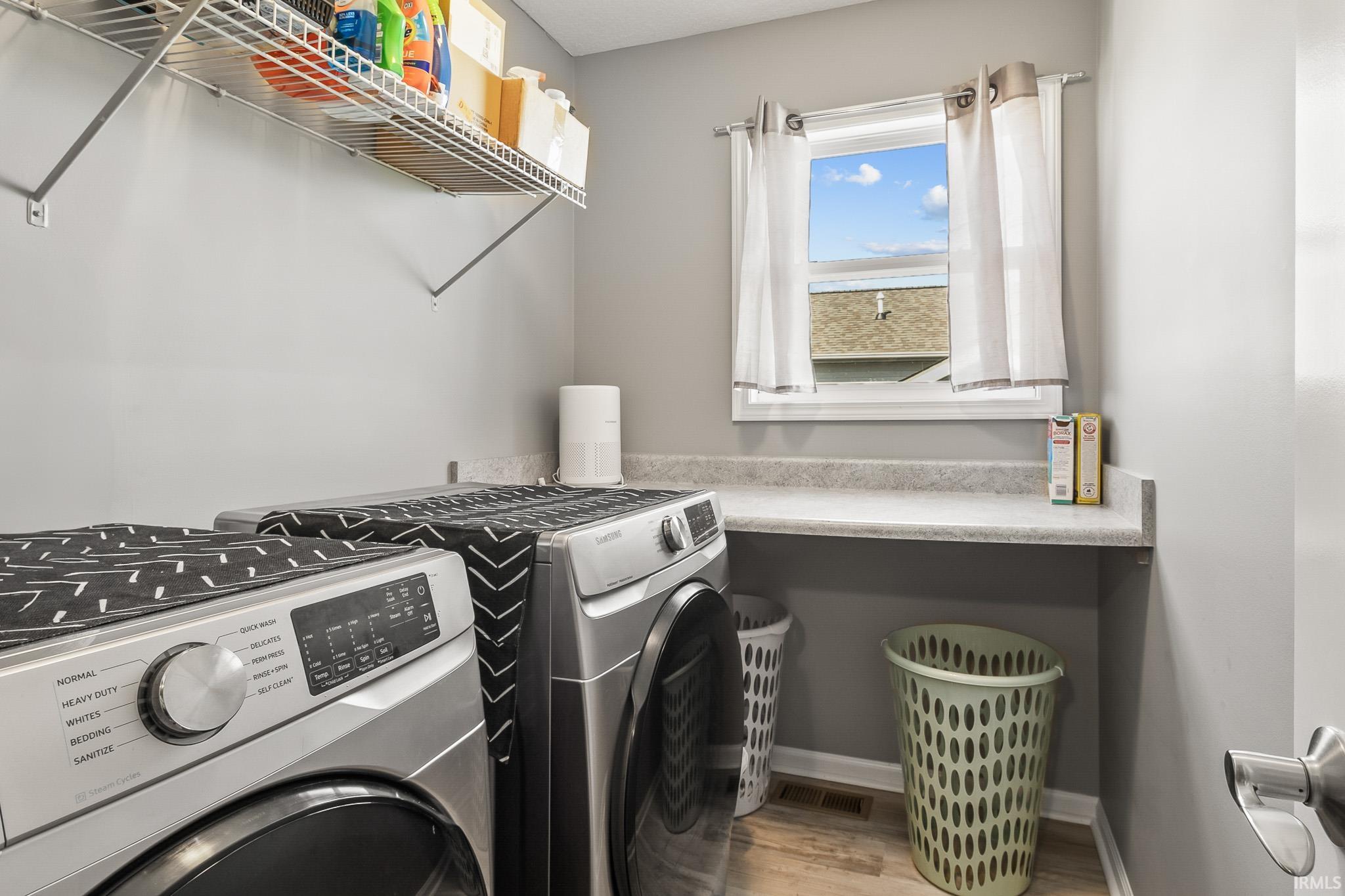 Dedicated laundry area featuring a window, built-in shelving, and a counter space