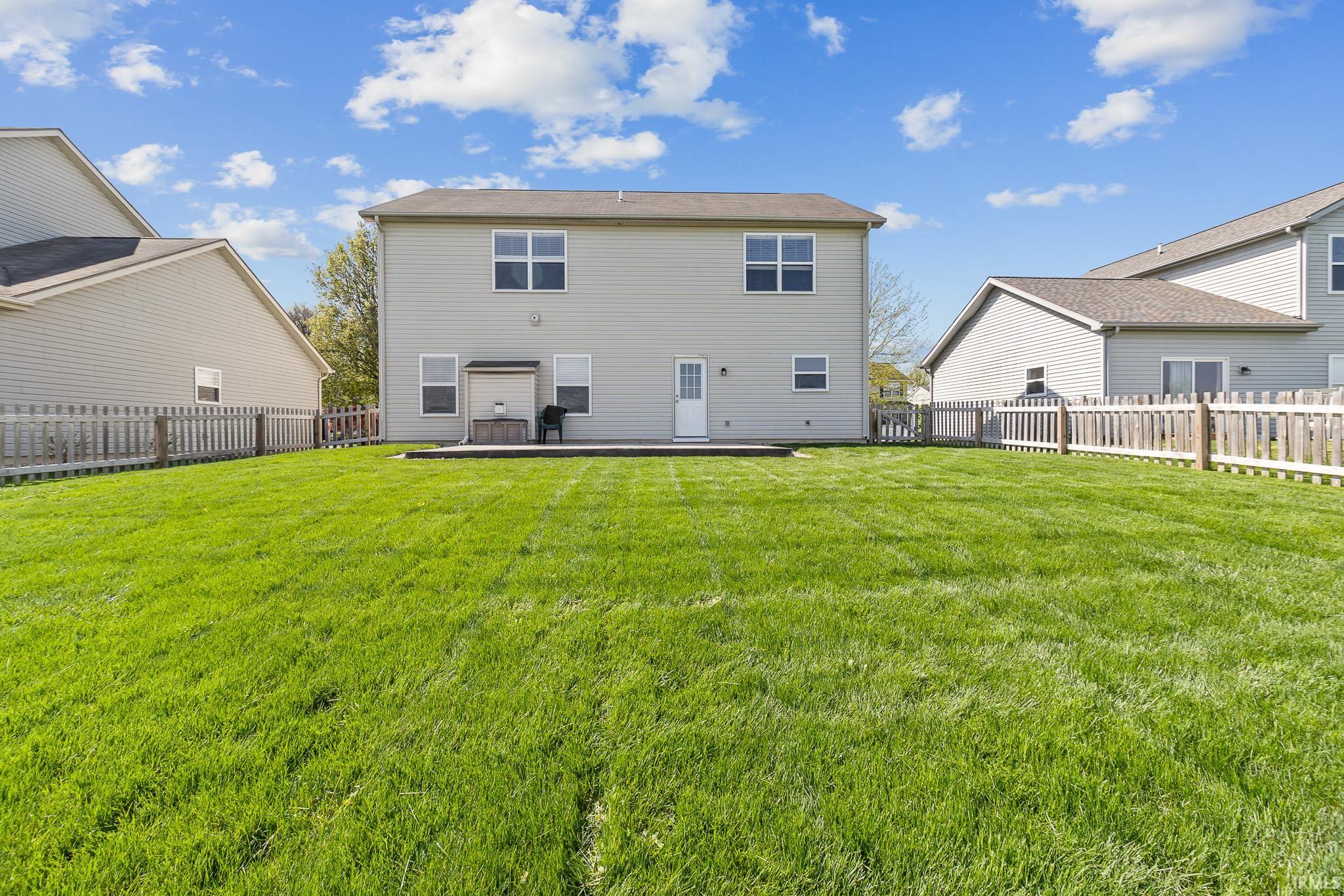 Expansive green lawn with a picket fence border