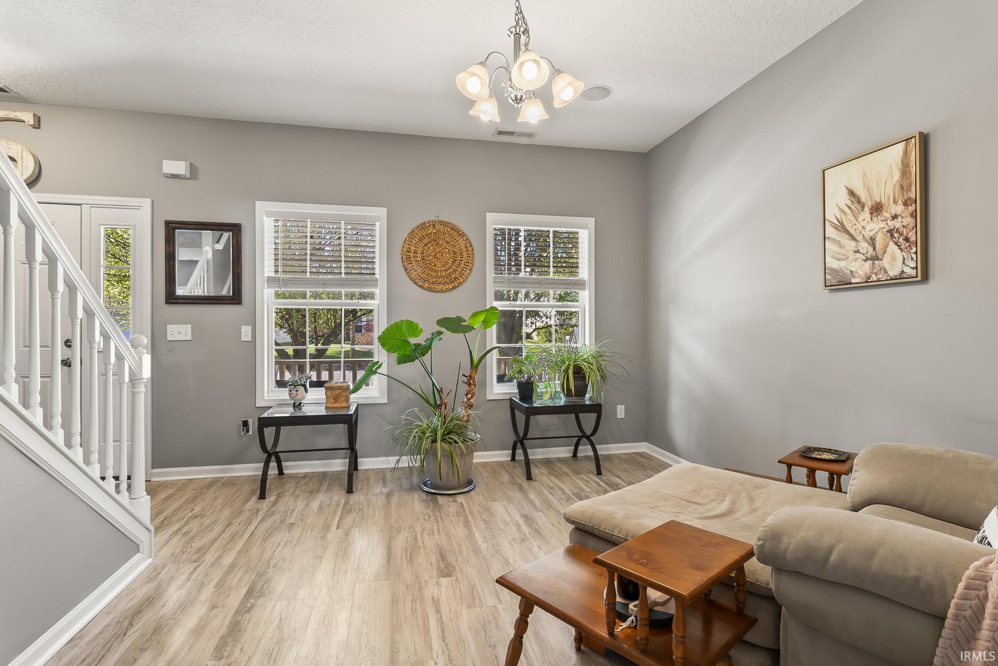 Spacious living area featuring wood-finish flooring, neutral wall tones, and white trim