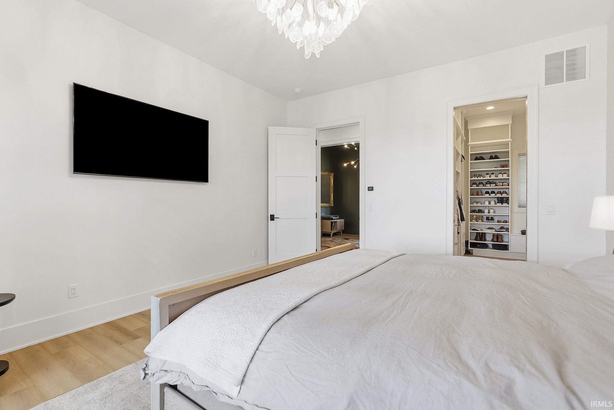 Bright interior space featuring a contemporary chandelier, light wood-finish flooring, and white baseboards