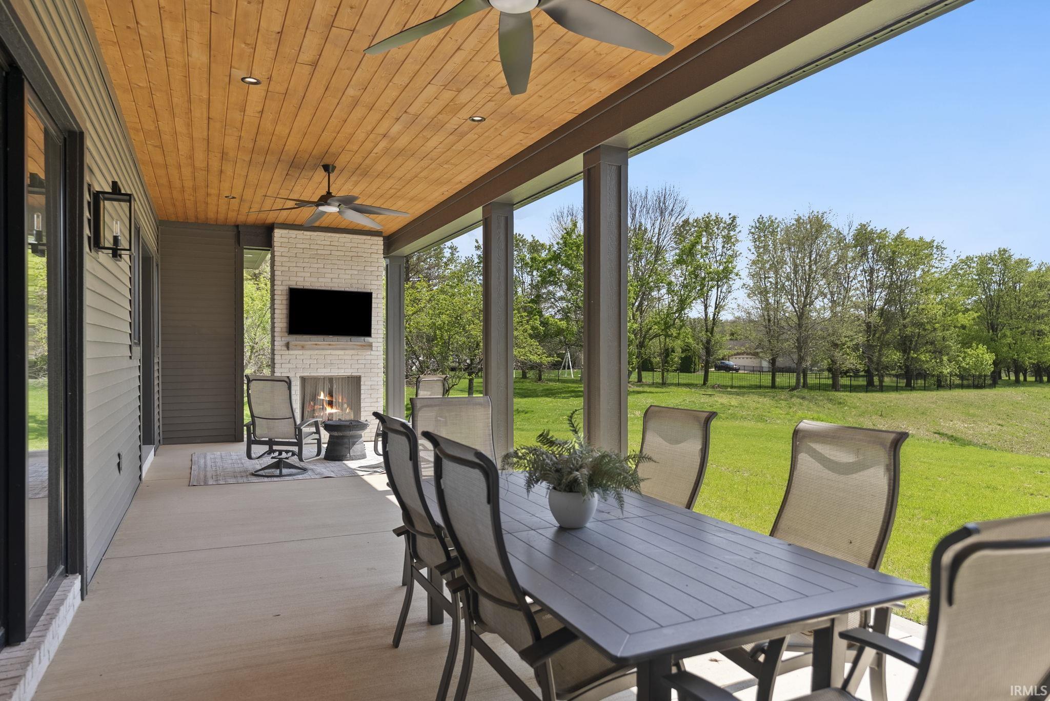 Spacious covered patio featuring a wood-finish ceiling, recessed lighting, and ceiling fans