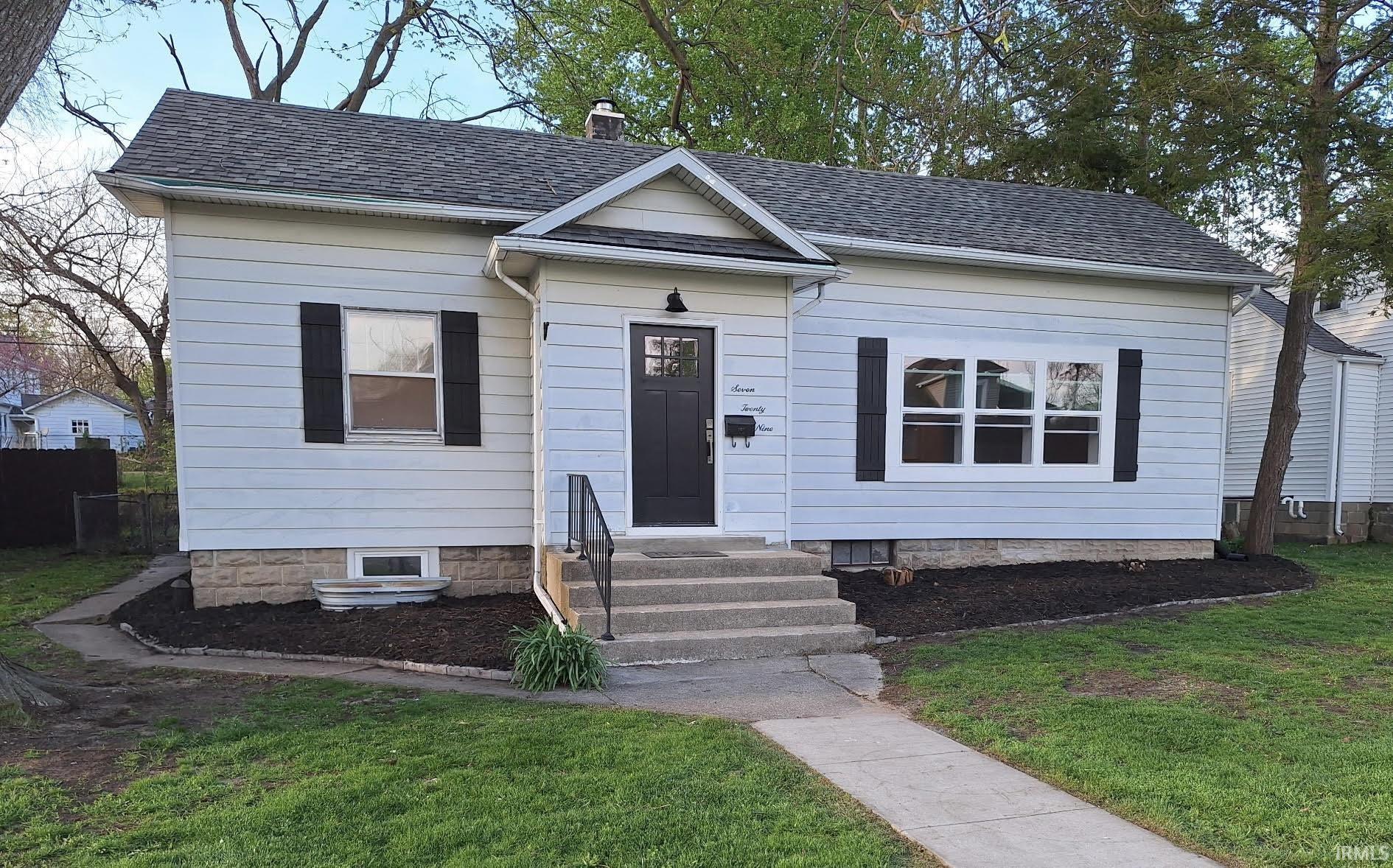 Single-story exterior with light-colored siding and a dark shingle roof