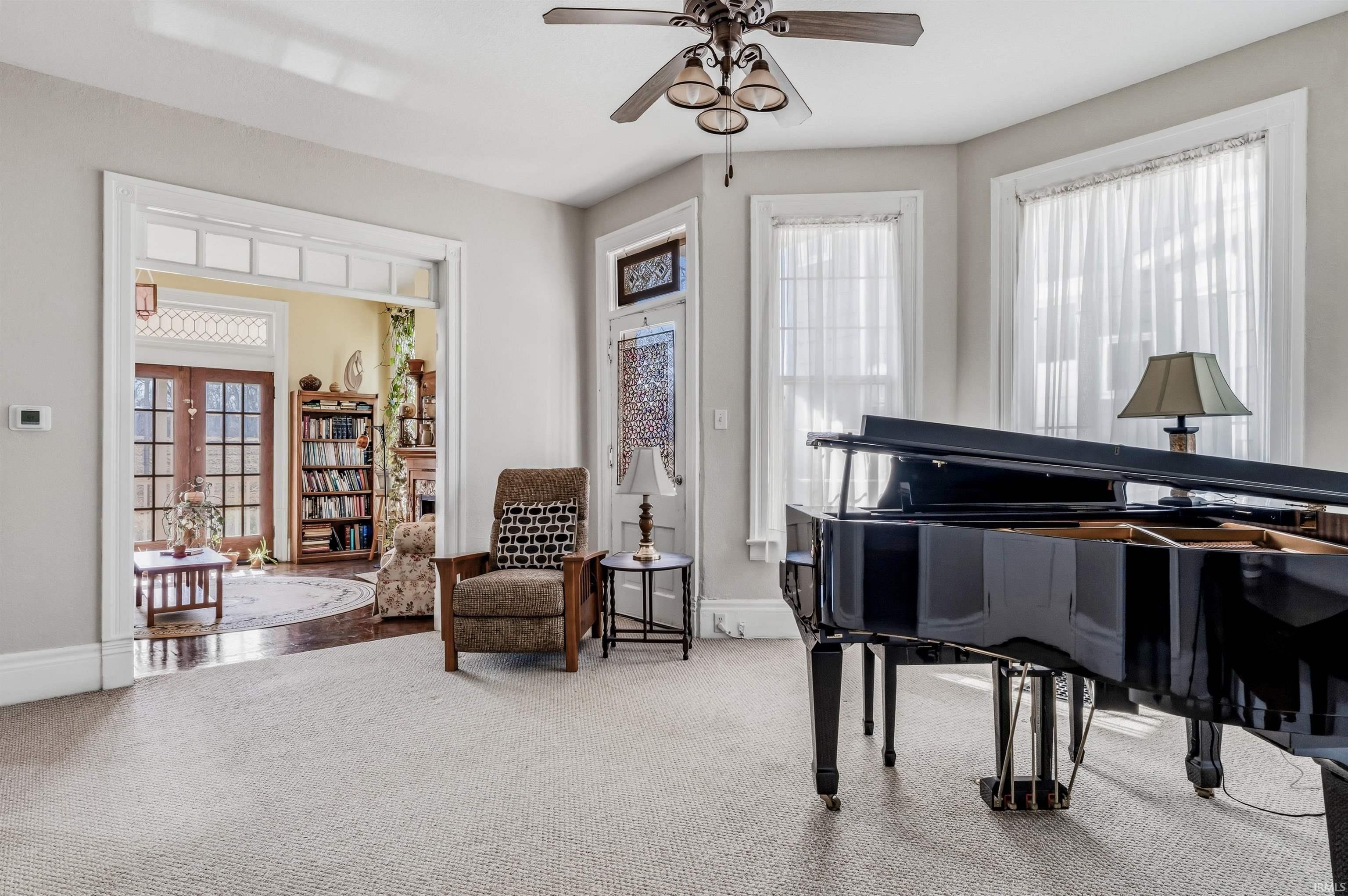 Living area featuring carpet, french doors, and ceiling fan