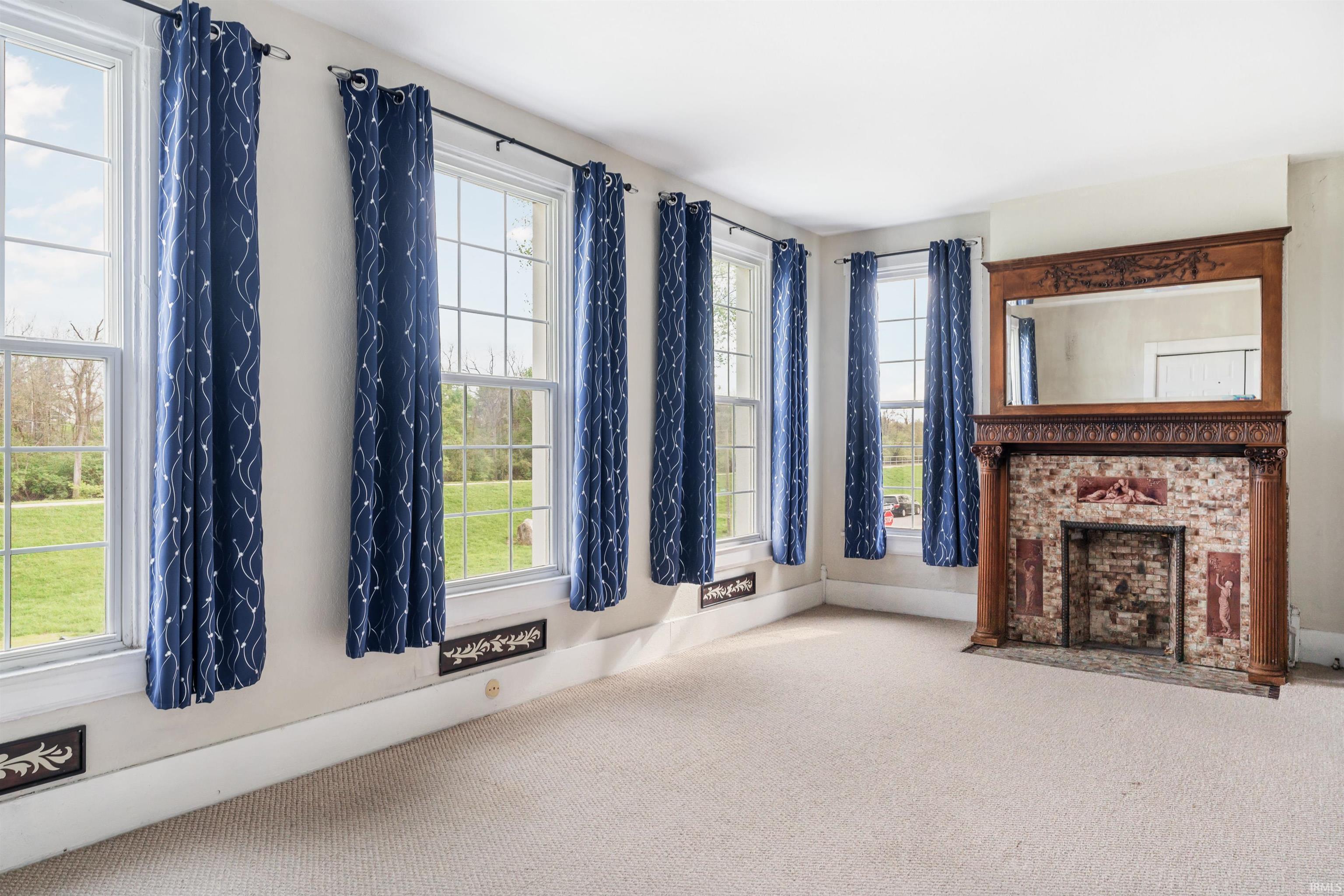Ornate wood fireplace surround with an integrated mirror and brick hearth