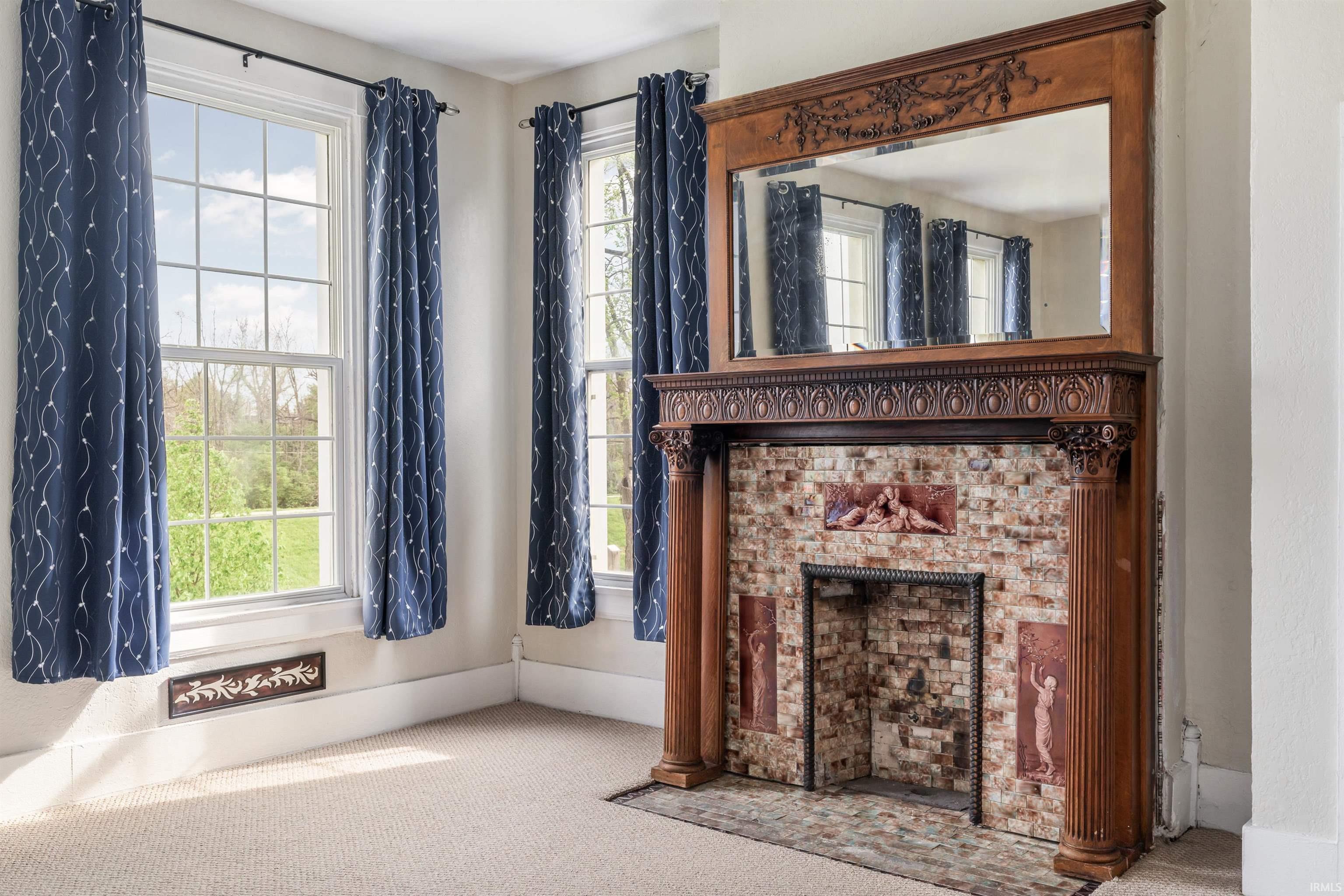 Ornate wood fireplace mantel with a built-in mirror, brick surround, and decorative tile accents
