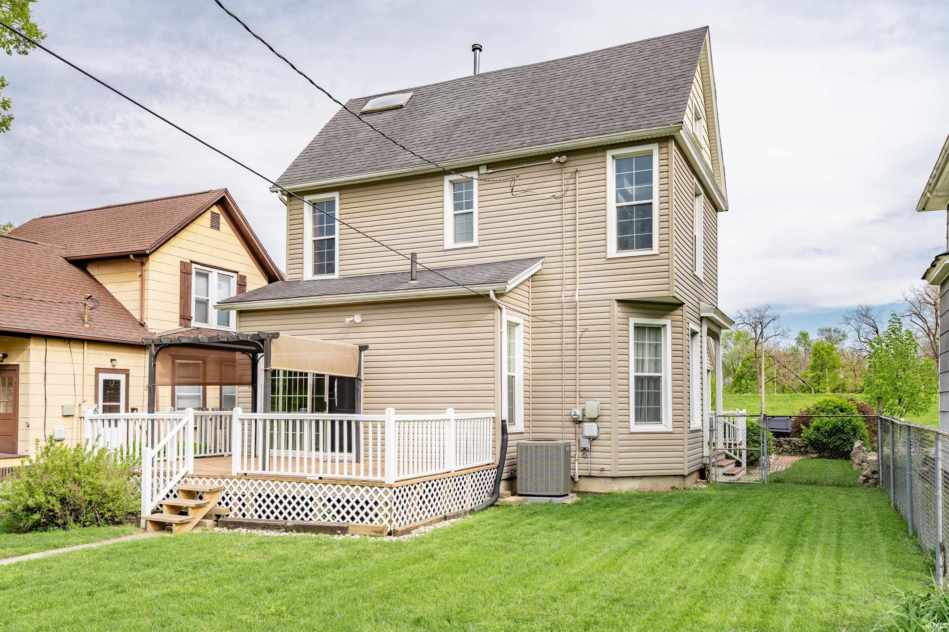 Rear exterior featuring beige siding and a multi-level wood deck with white railings