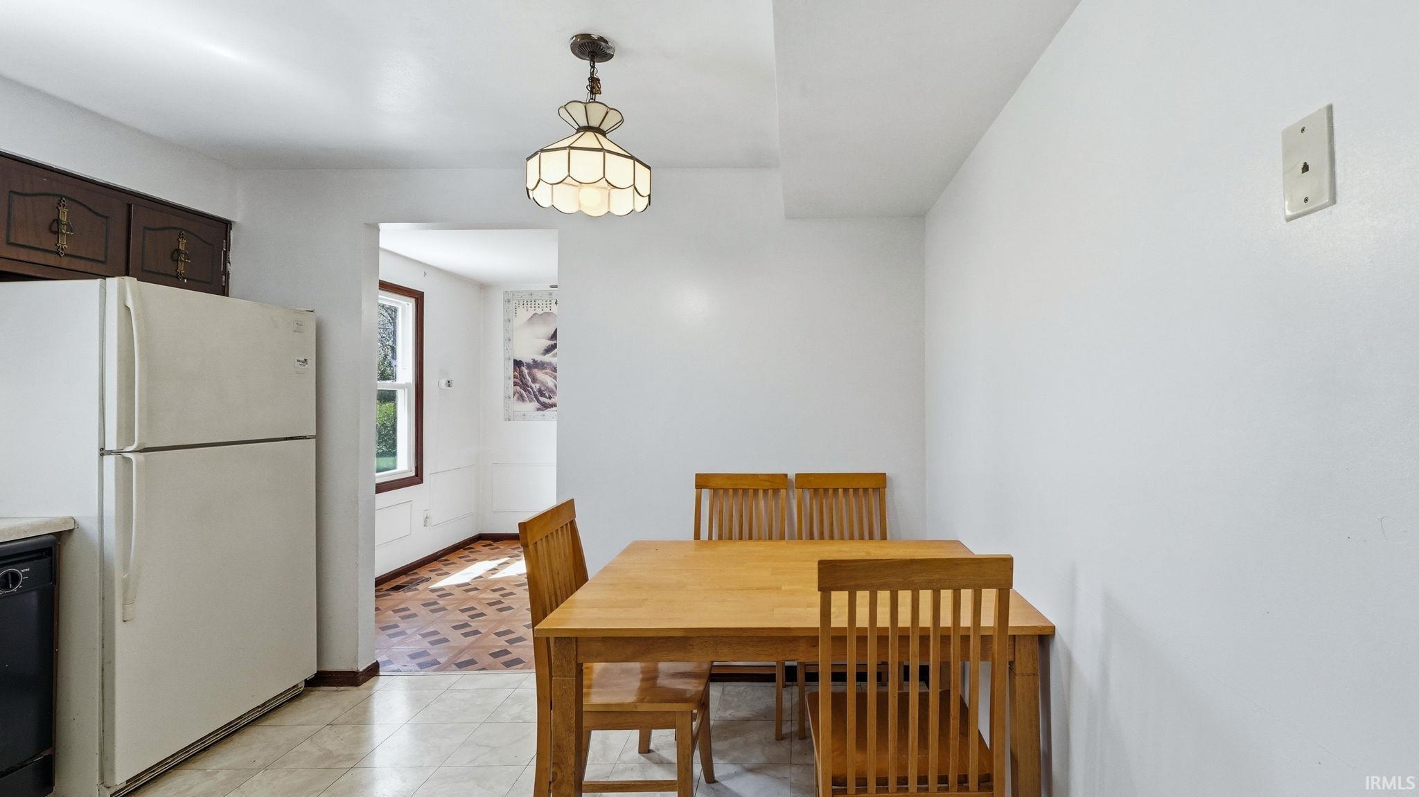 Bright kitchen area featuring a built-in refrigerator, dark lower cabinetry, and light-colored tiled flooring
