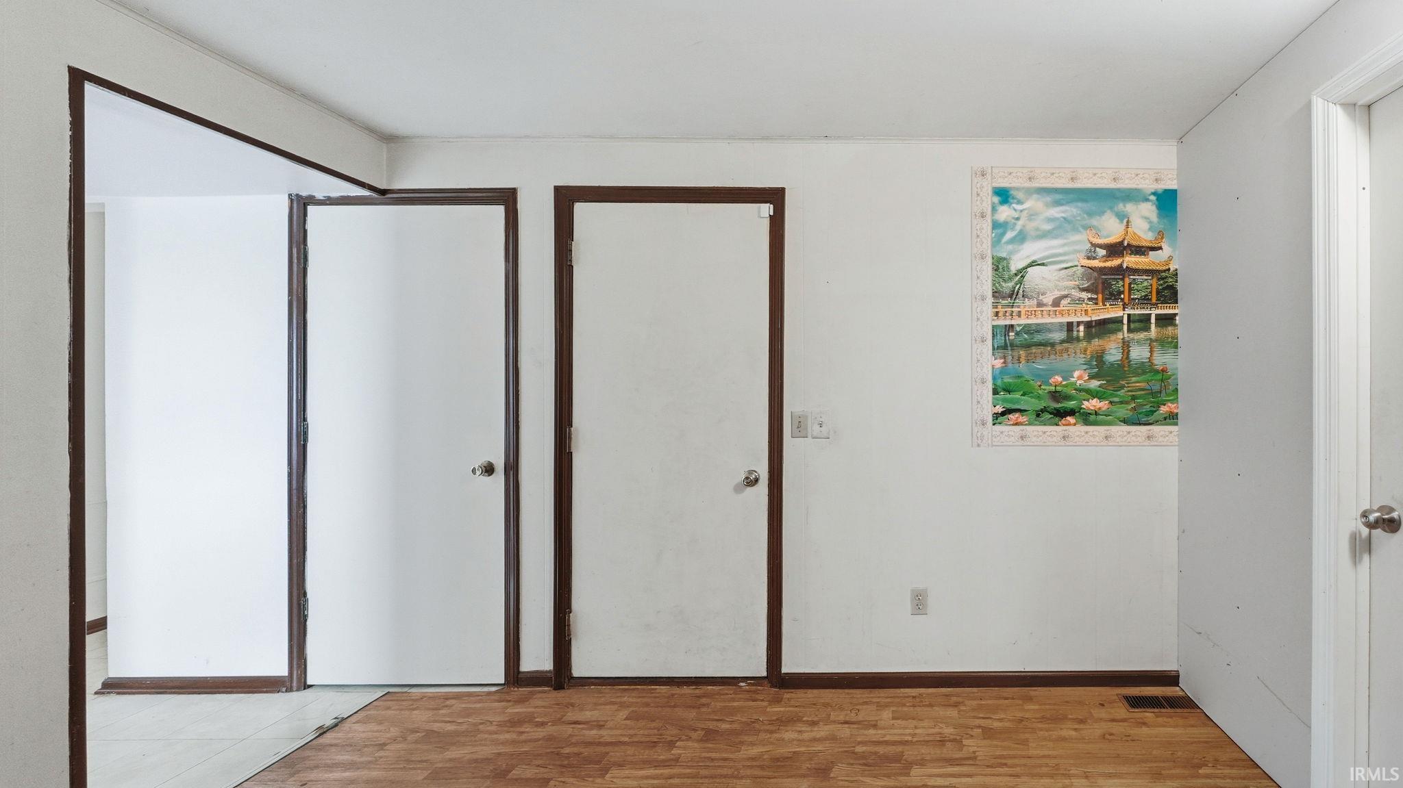 Wood-finish flooring with white walls and dark trim