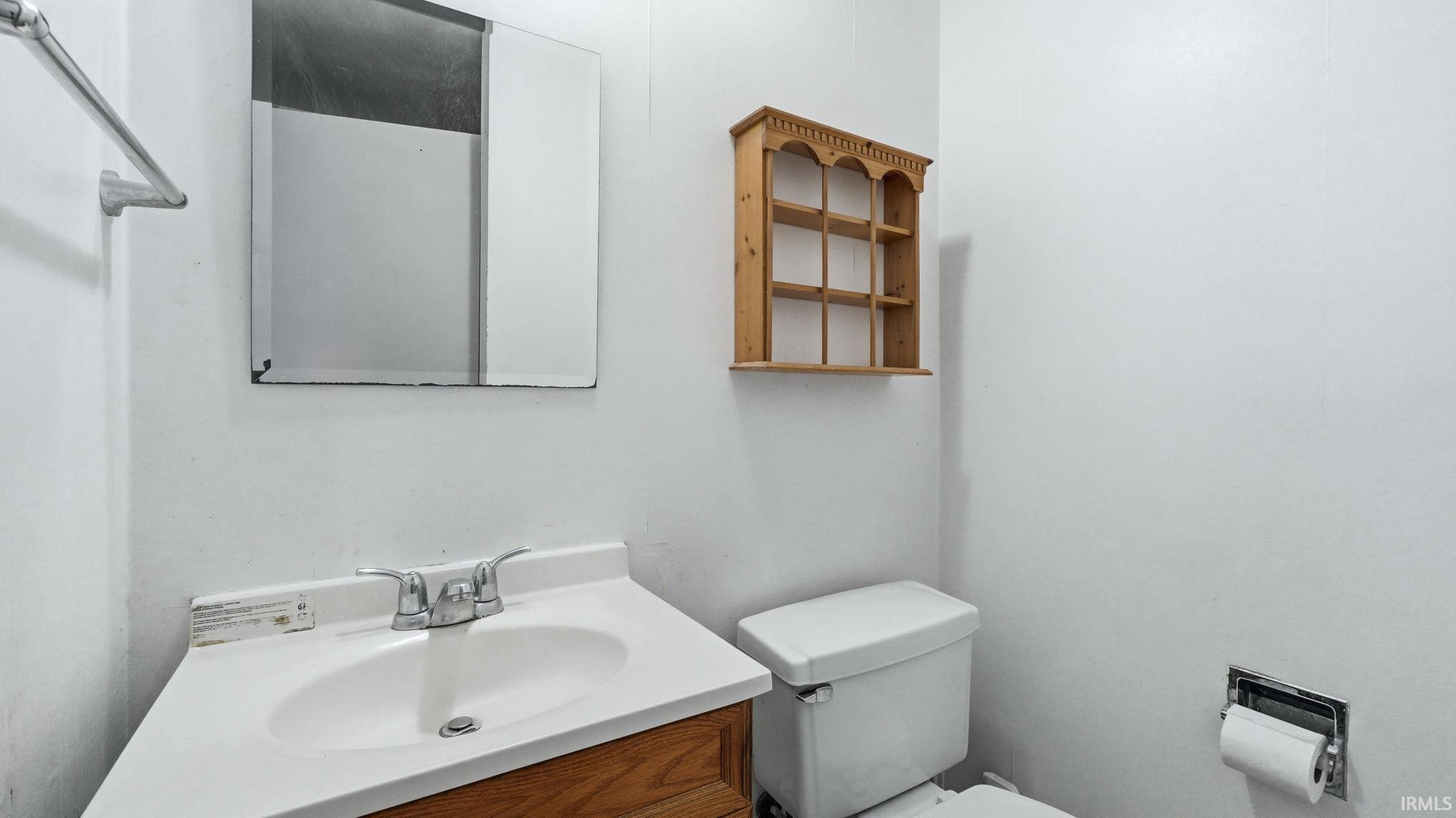 Bathroom vanity with integrated sink, chrome faucet, and wood-finish cabinetry