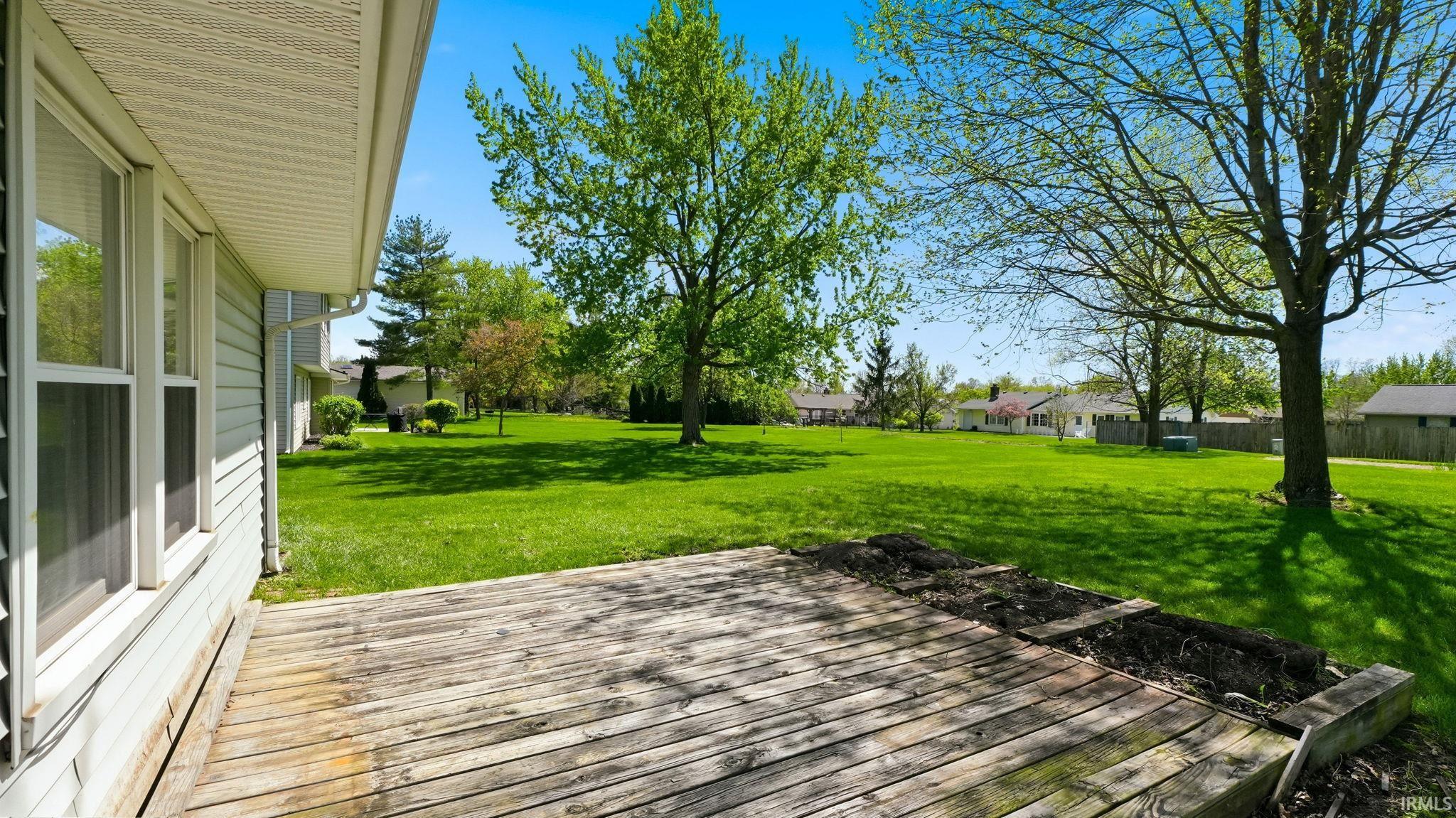 Expansive outdoor deck with natural wood planks, featuring an integrated planter box