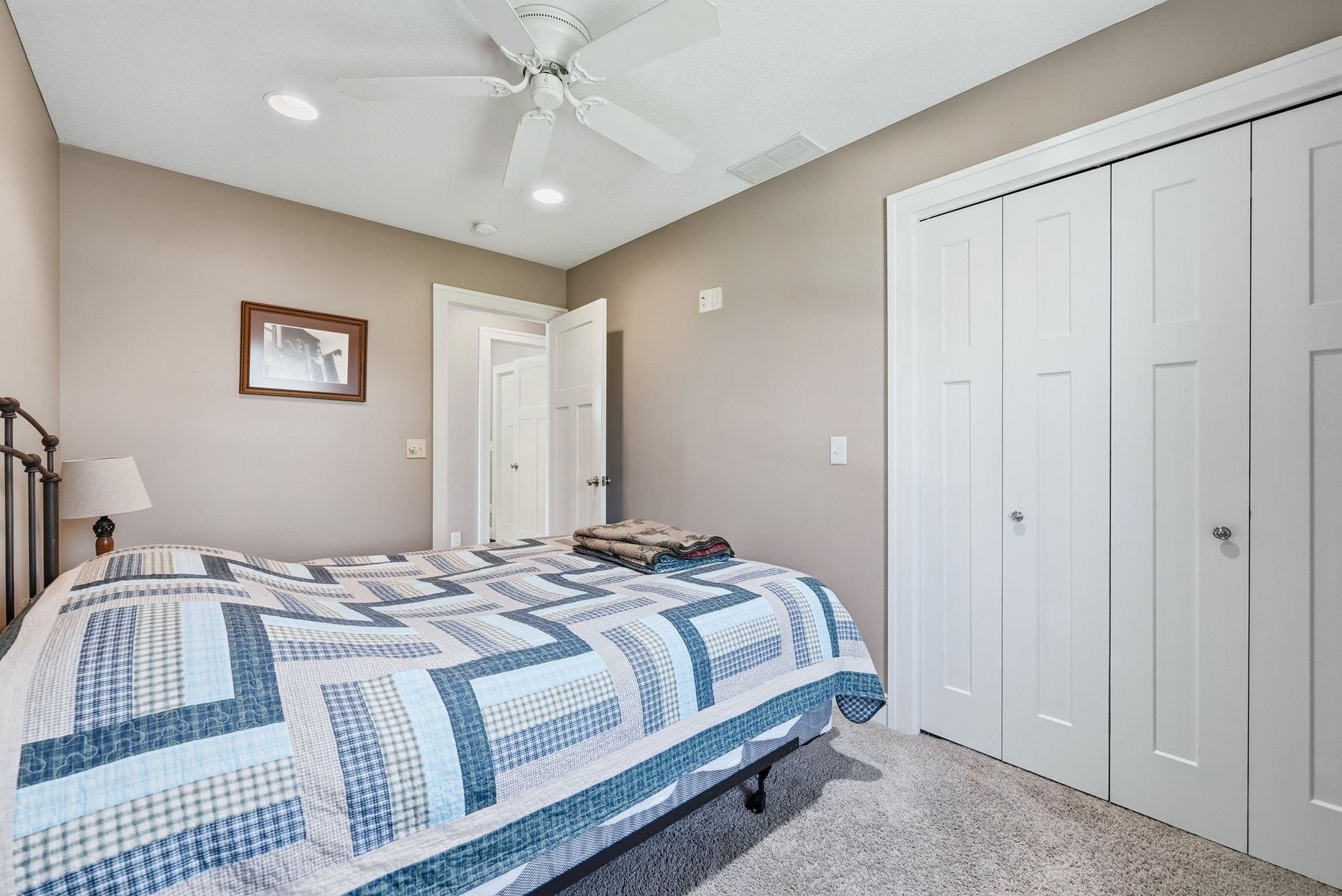 Bedroom featuring light gray walls, white ceiling fan with integrated lighting, recessed lighting, and soft carpet flooring