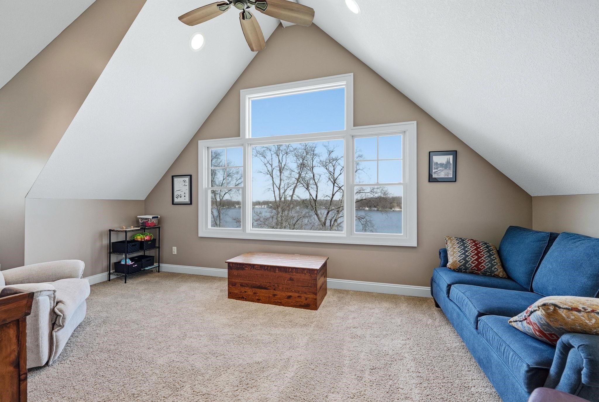 Attic room with sloped ceilings, recessed lighting, and a ceiling fan