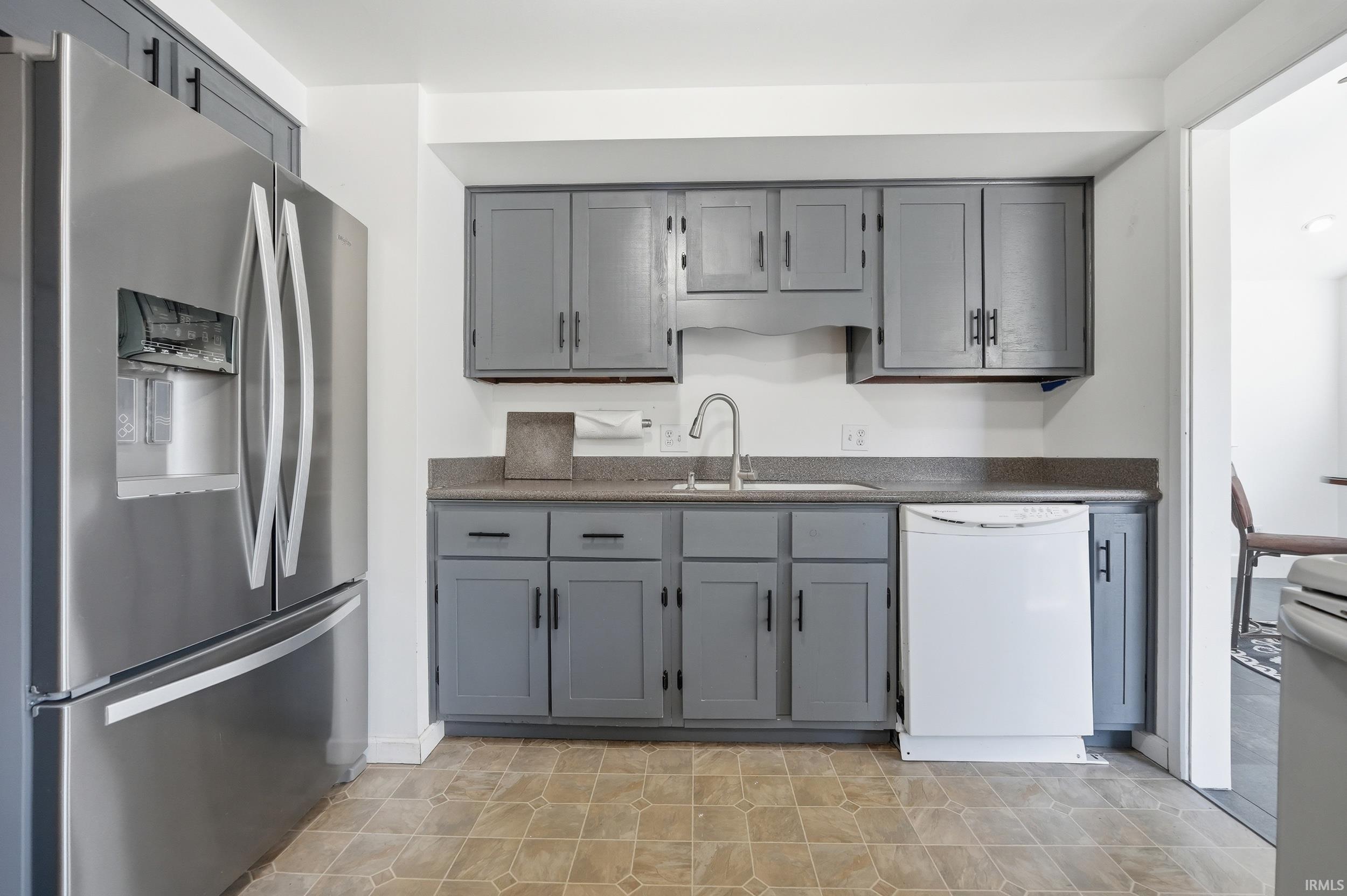 Kitchen featuring gray cabinetry, a stainless steel French door refrigerator, a white dishwasher, a stainless steel sink with a gooseneck faucet, and stone-finish countertops