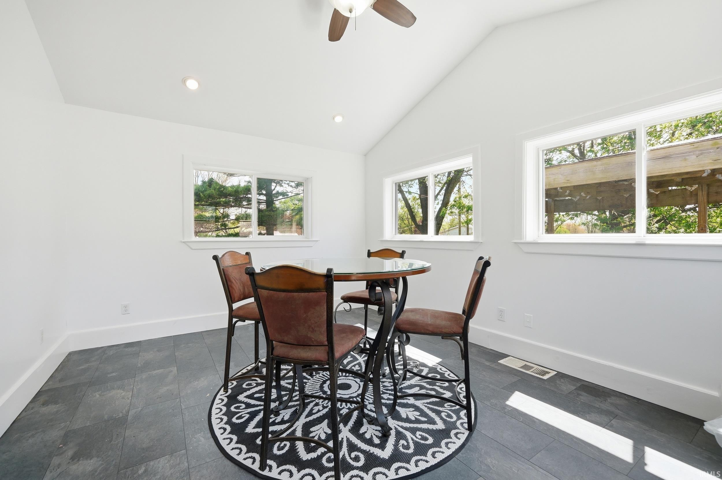 Vaulted ceilings with recessed lighting and a ceiling fan