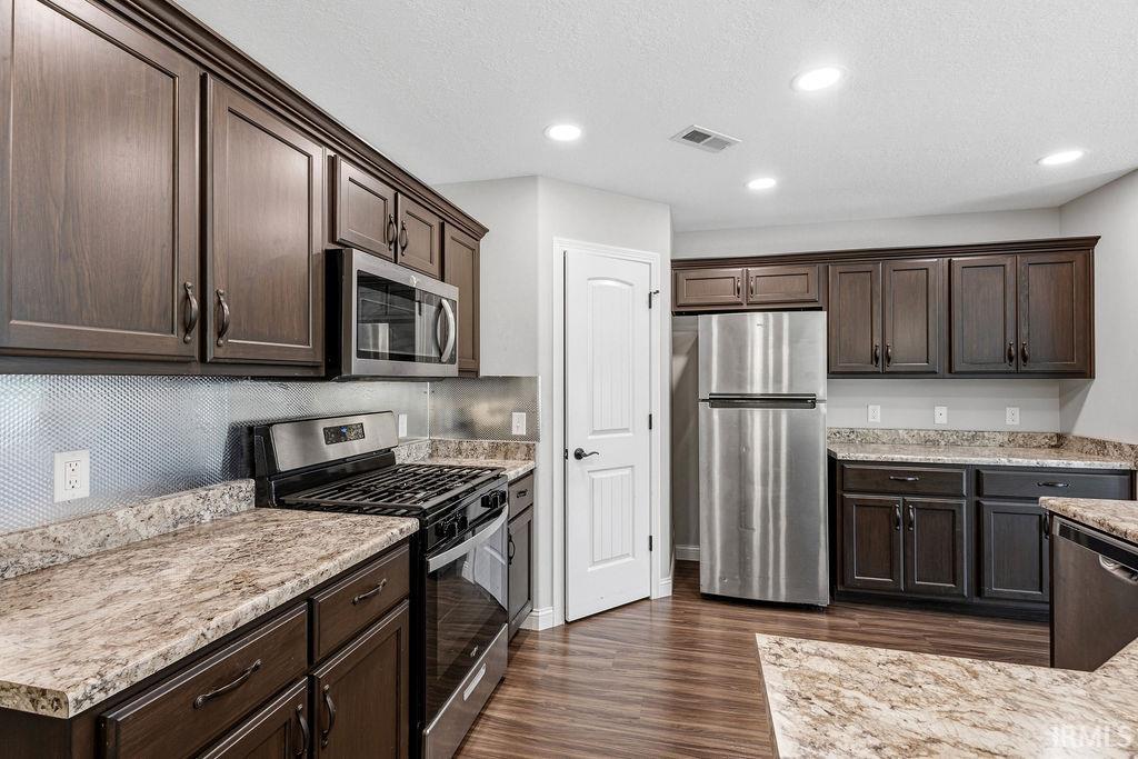 Kitchen featuring dark wood cabinetry and wood-finish flooring