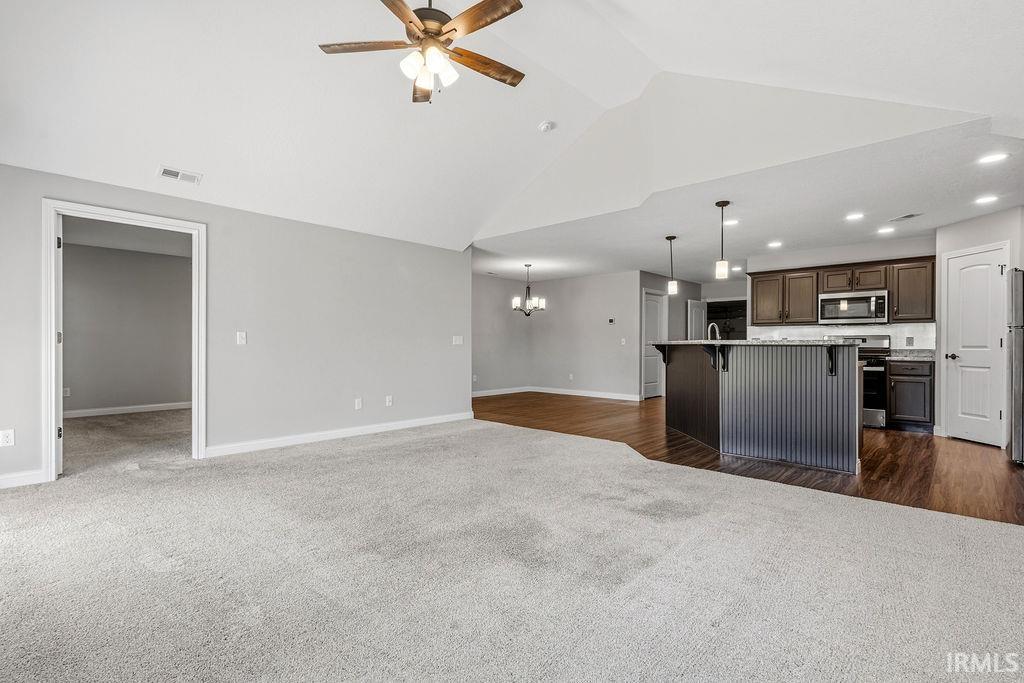 Open-concept living space featuring vaulted ceilings and a ceiling fan