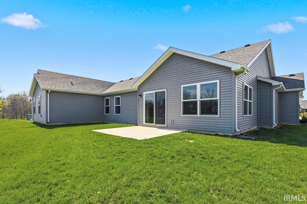 Rear exterior featuring grey horizontal siding, a concrete patio, and a sliding glass door