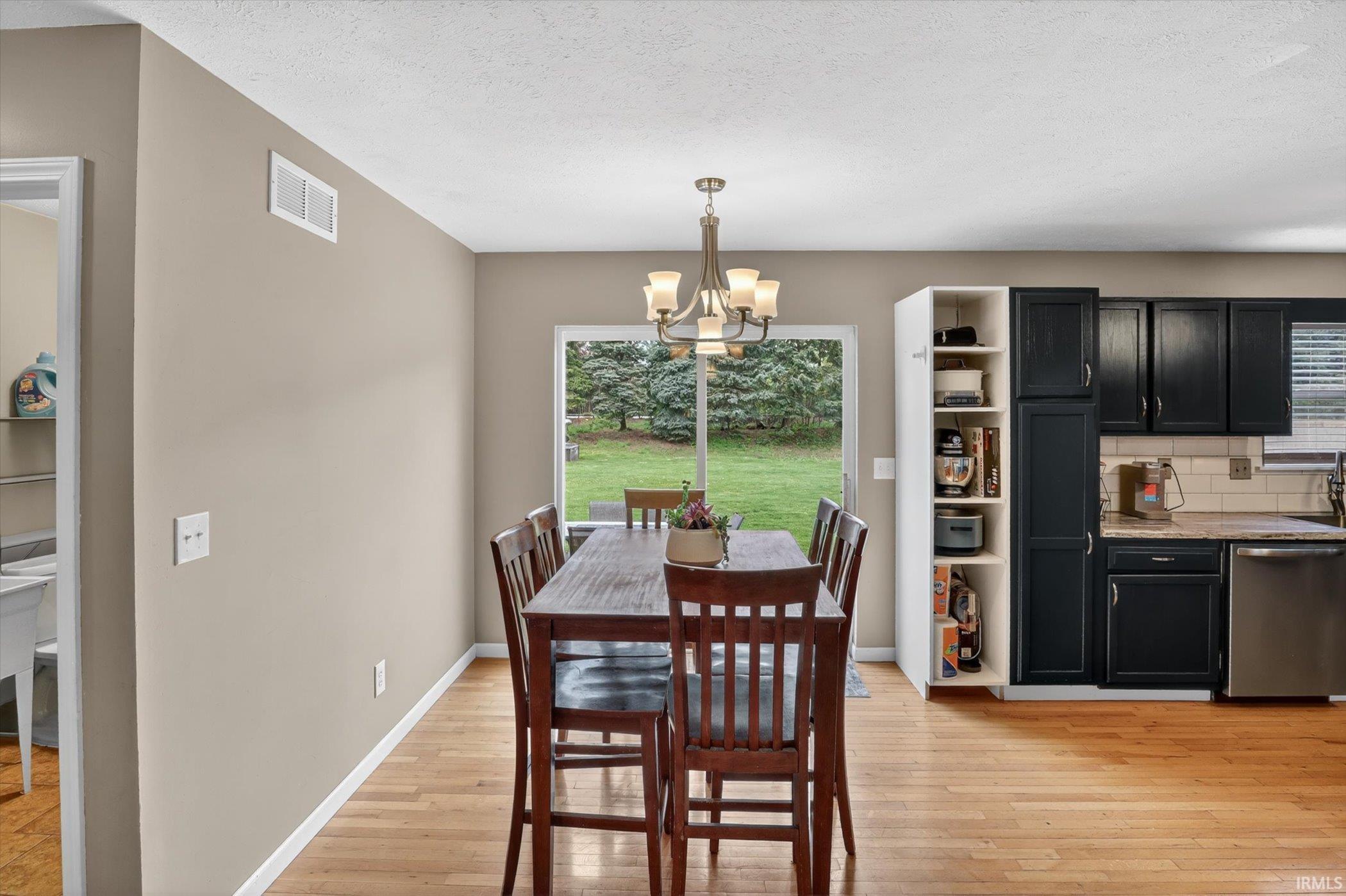 Open-concept dining area featuring wood-finish flooring and a glass sliding door