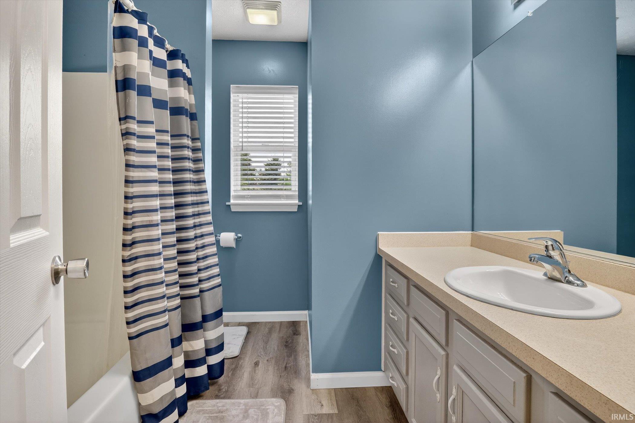 Bathroom featuring a single vanity with an integrated sink, polished chrome faucet, and ample under-sink storage