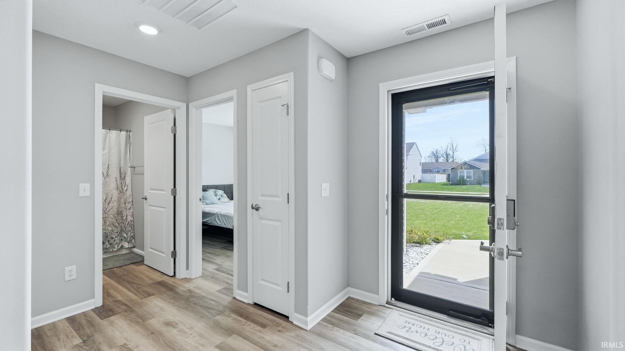 Entryway featuring wood-finish flooring, light gray walls, and white trim