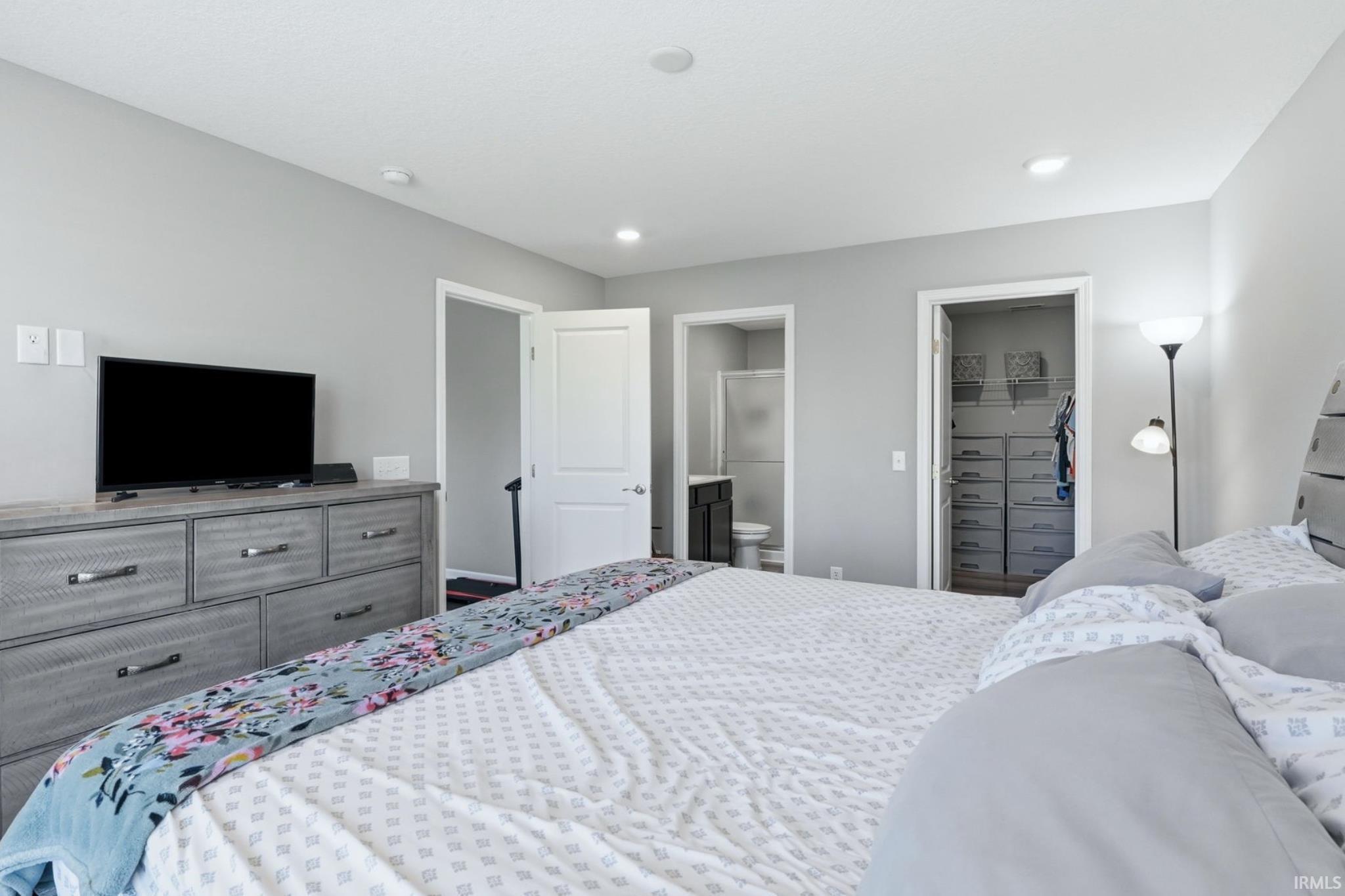 Bedroom with light gray walls, white trim, and recessed lighting
