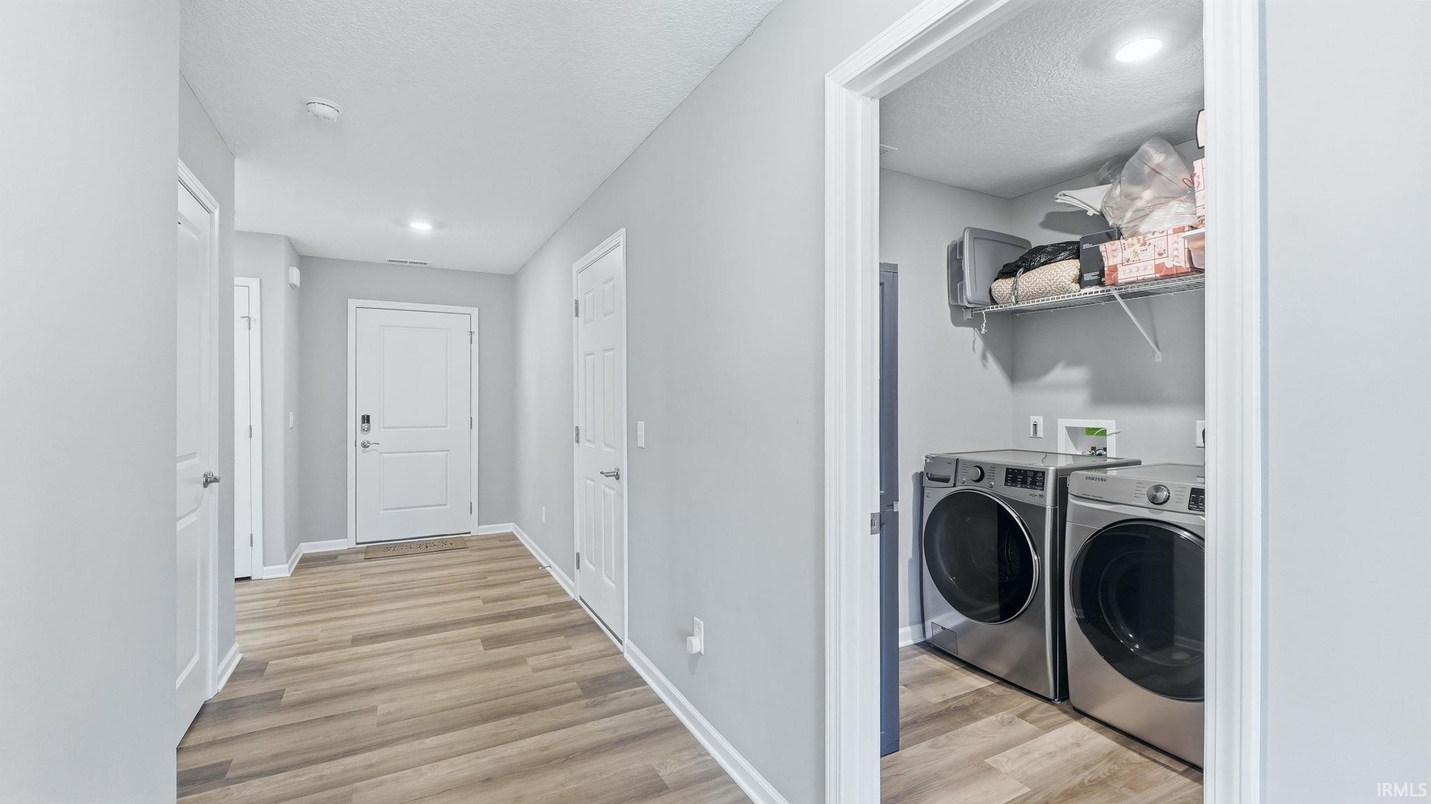 Hallway featuring wood-finish flooring, light grey walls, and recessed lighting