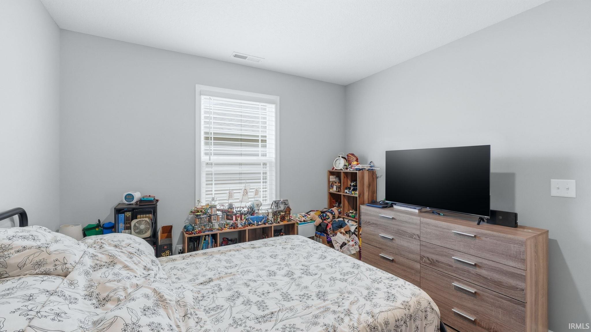 Light gray walls complement a single window with blinds
