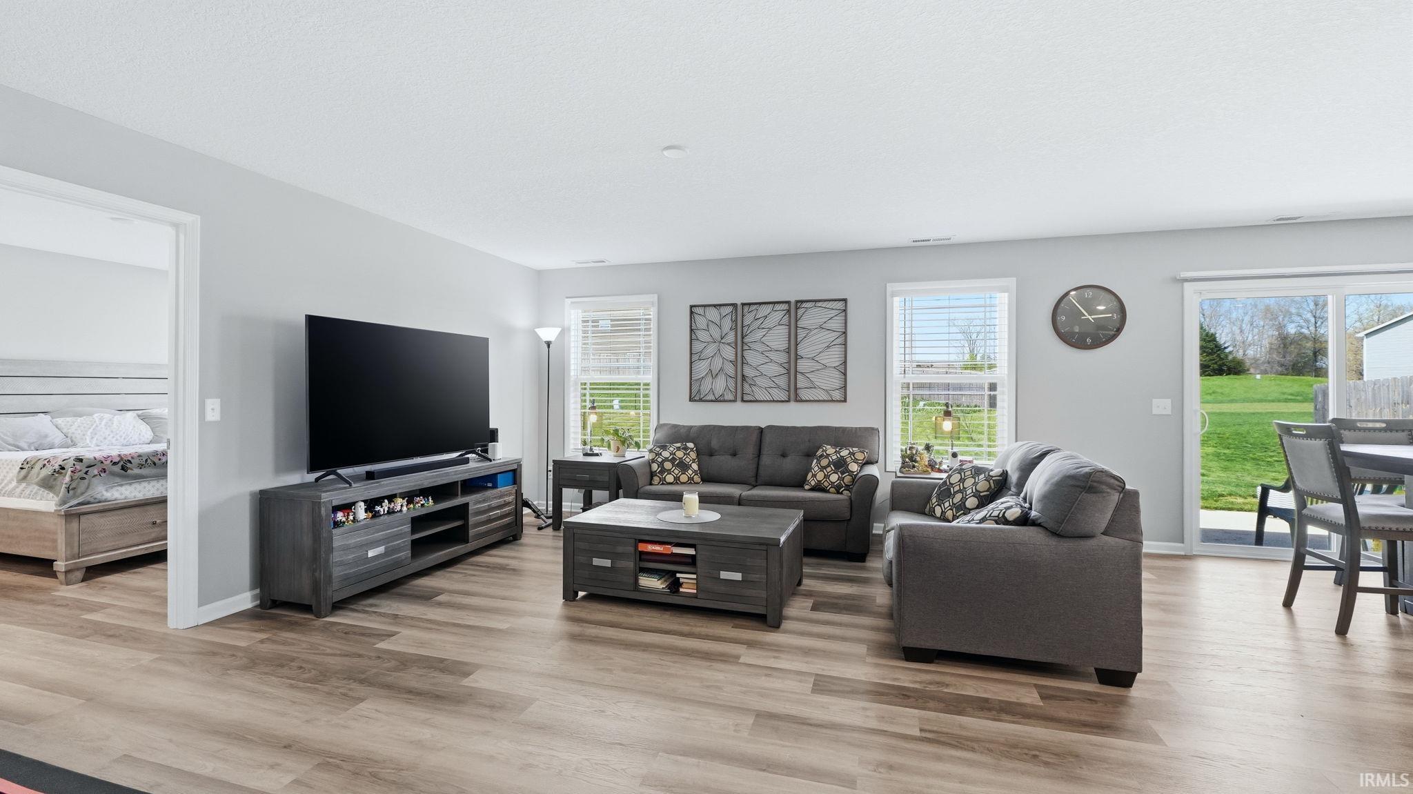 Open-concept living space featuring wood-finish flooring, light gray wall paint, and white trim
