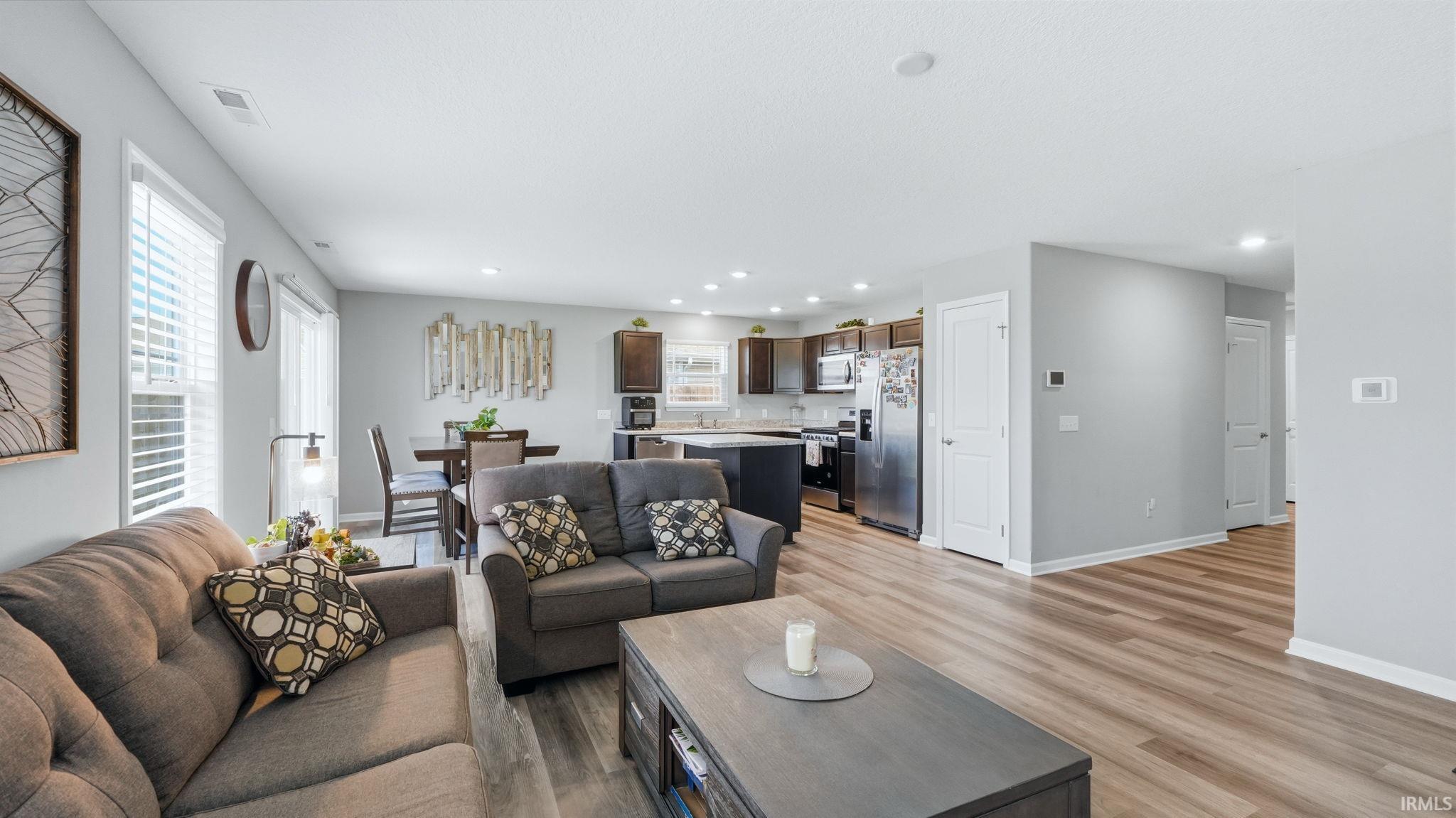 Open-concept living space featuring wood-finish flooring and recessed lighting