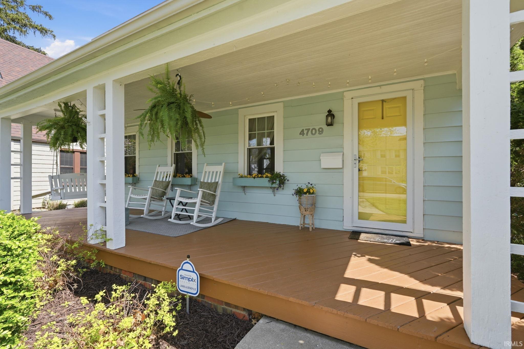 Expansive covered front porch with a wood-finish deck