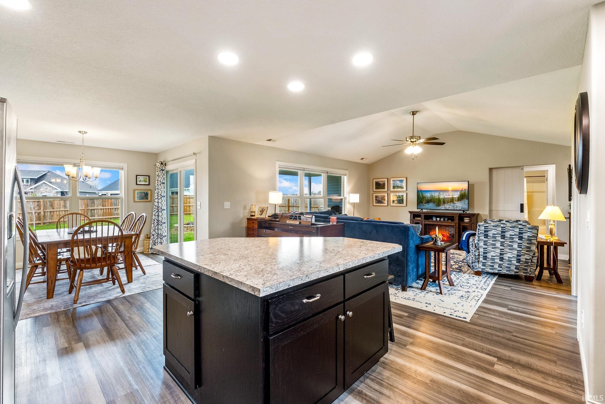 Kitchen island featuring a light-toned countertop and dark cabinetry with silver hardware