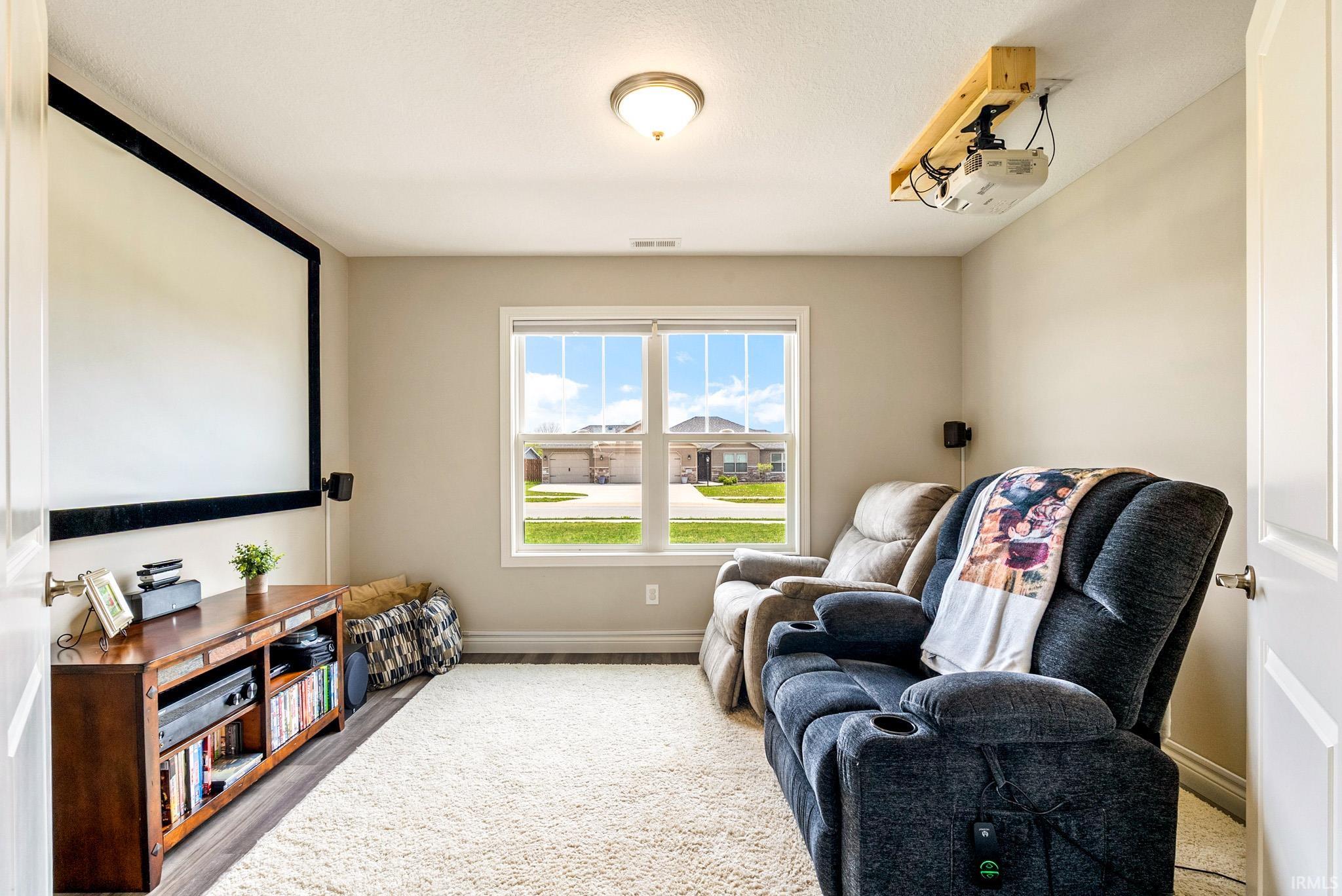 Dedicated media room featuring a large projection screen and ceiling-mounted projector