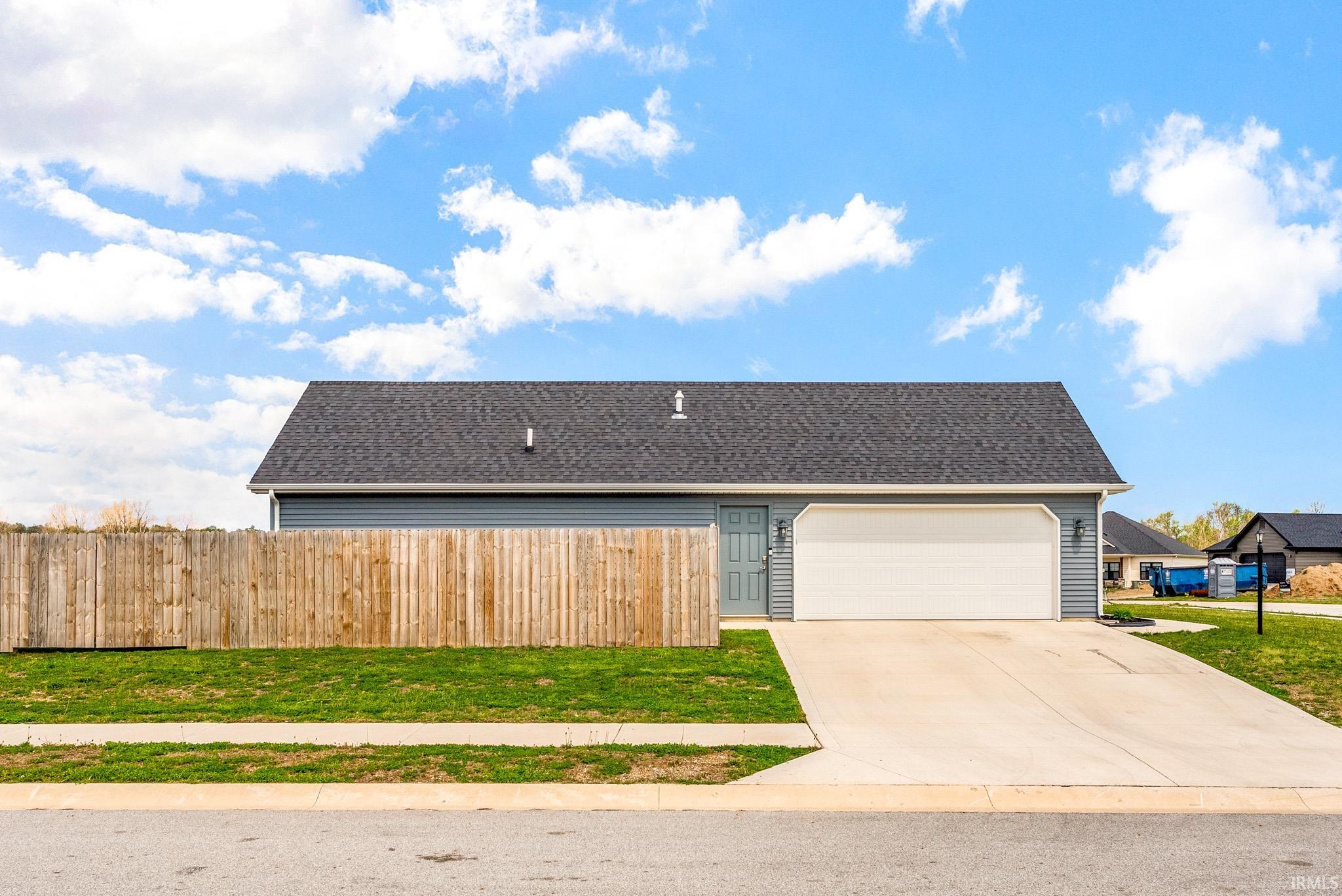 Single-story residence featuring light blue siding and a dark shingle roof