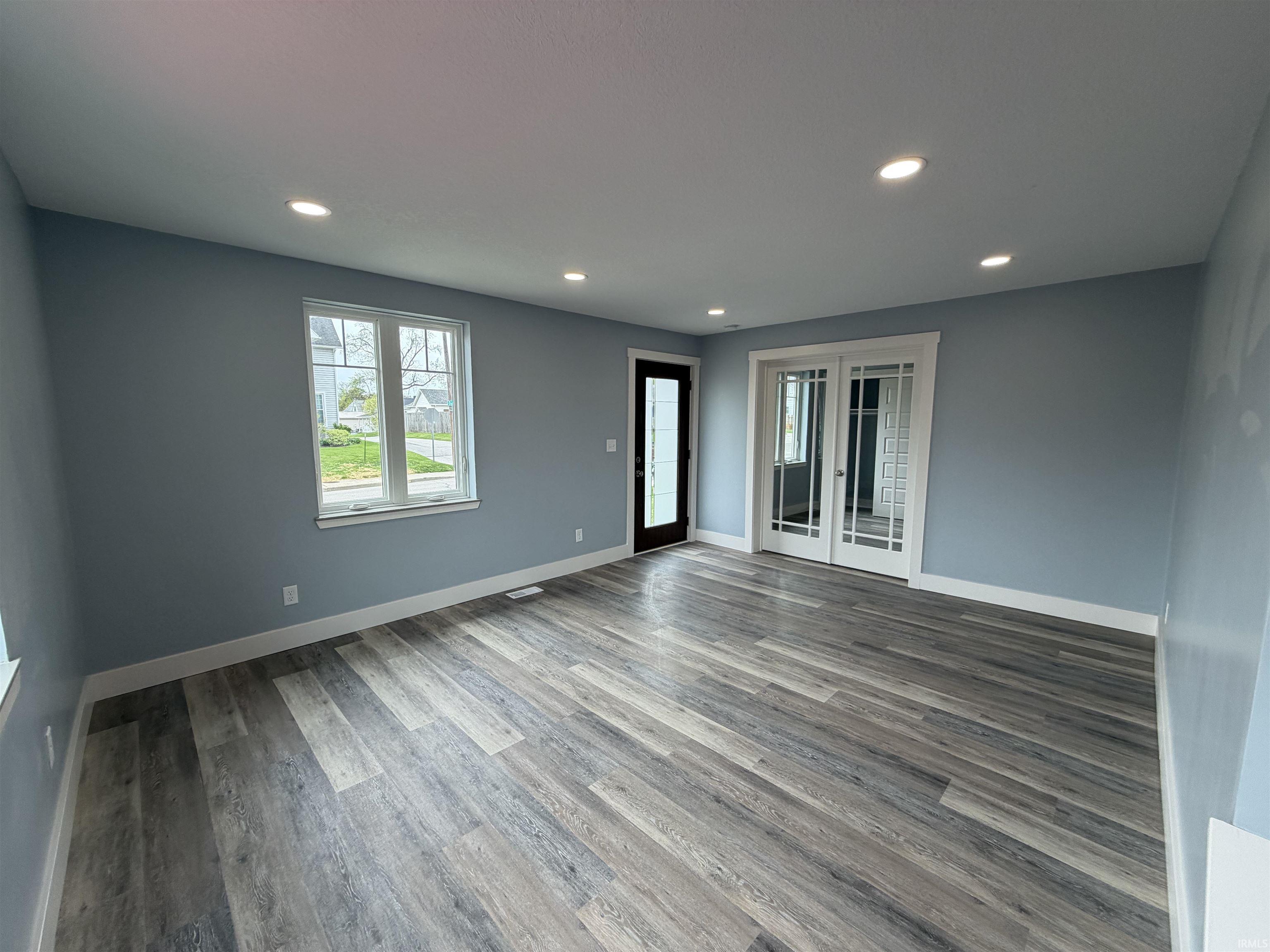 Unfurnished living room featuring french doors, light wood-style floors, and recessed lighting