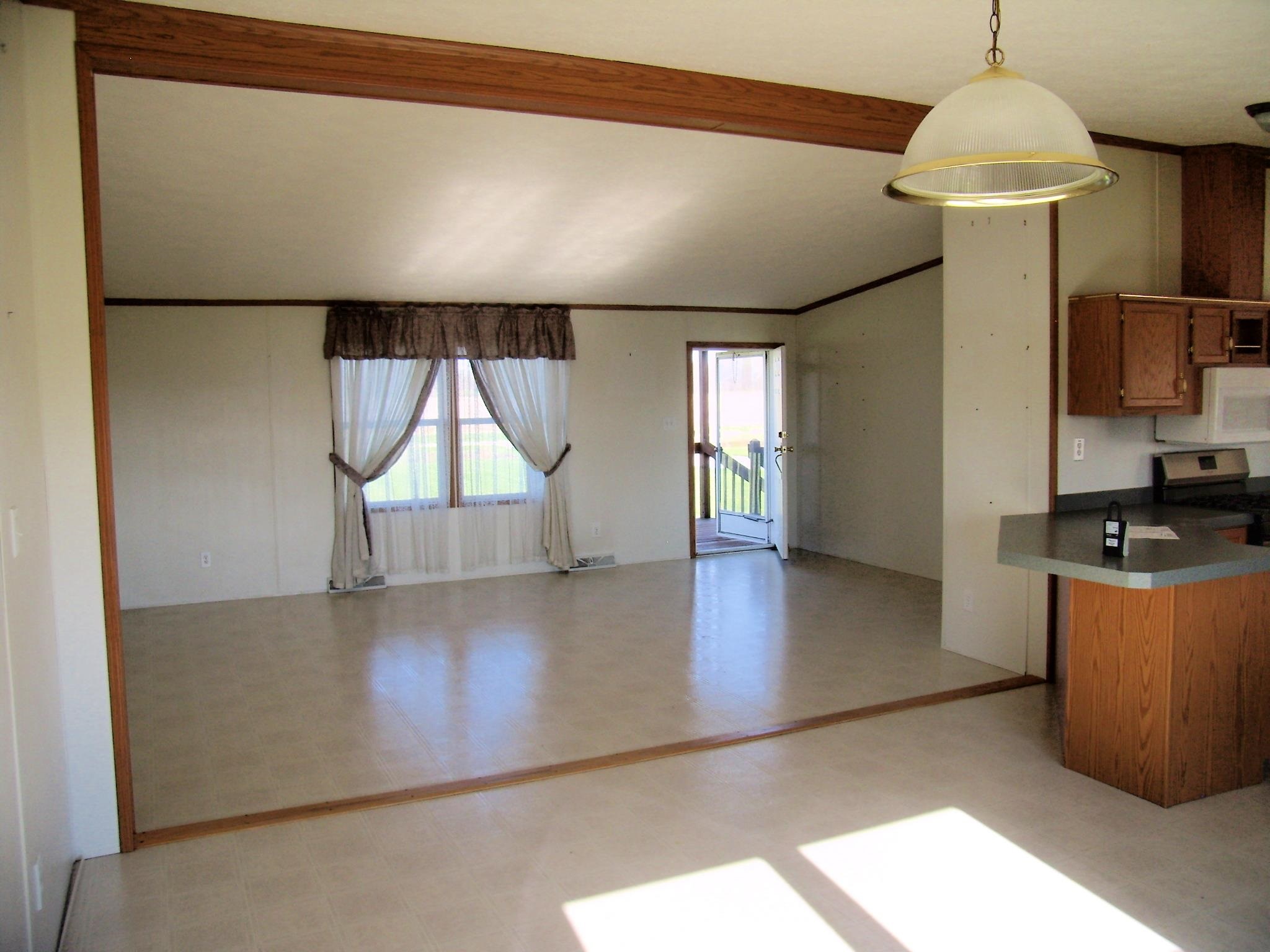 Spacious interior featuring neutral wall tones, wood-finish trim, and light-colored flooring