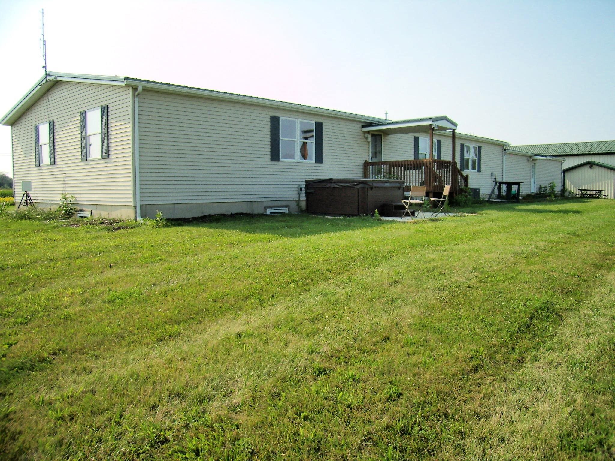 Expansive green lawn with a white vinyl-sided home