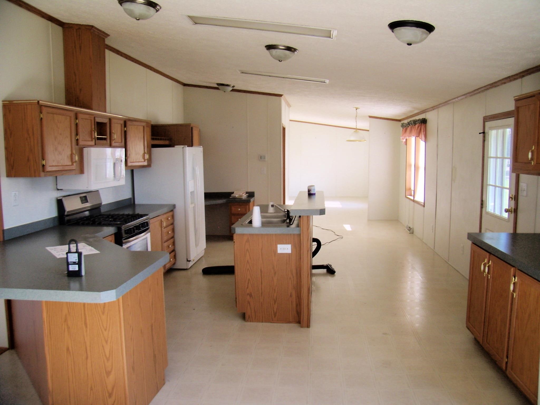 Spacious kitchen featuring wood-finish cabinetry, dark countertops, and stainless steel range