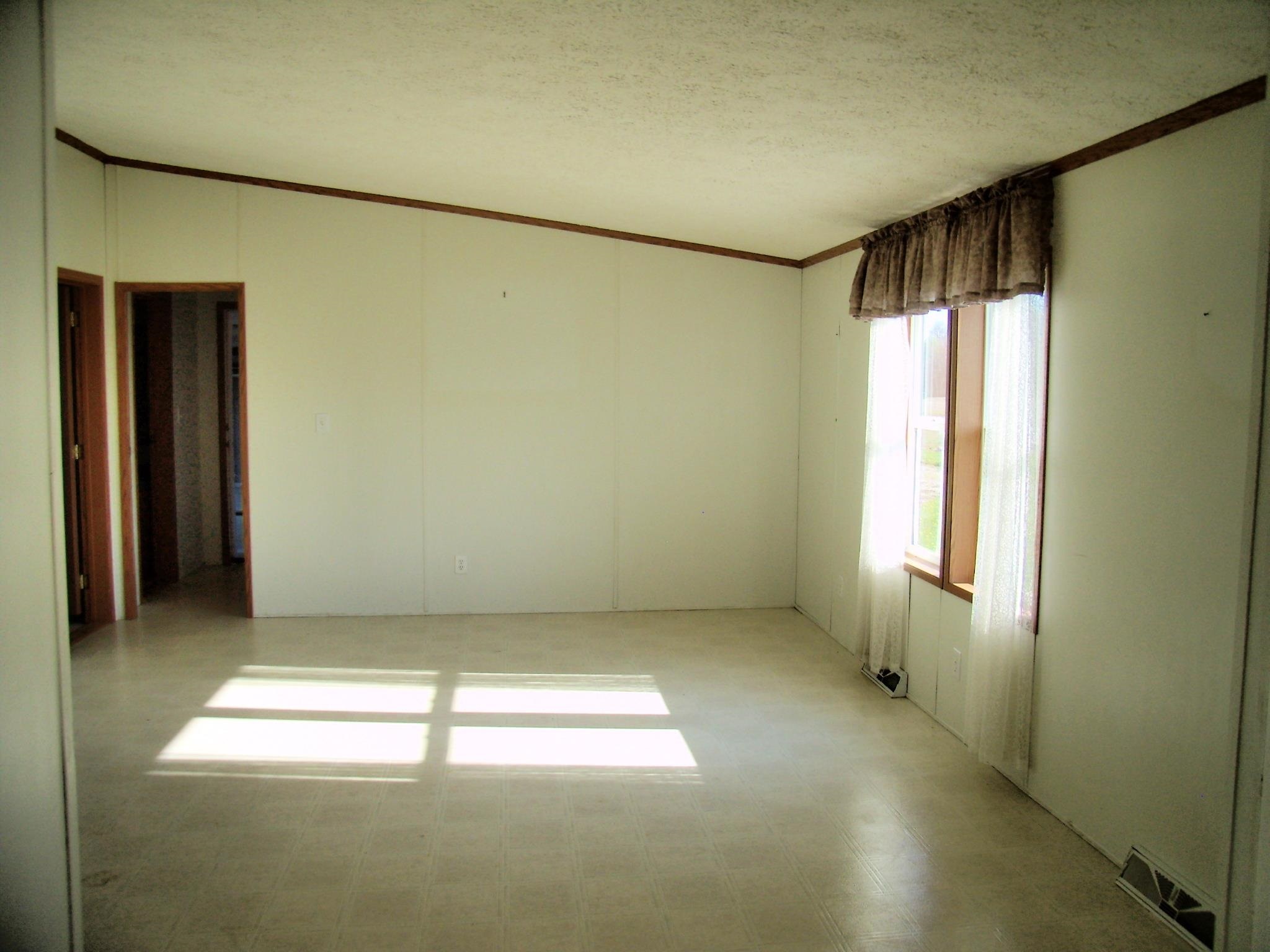 Neutral wall paneling with wood-finish trim and a window with wood-finish framing