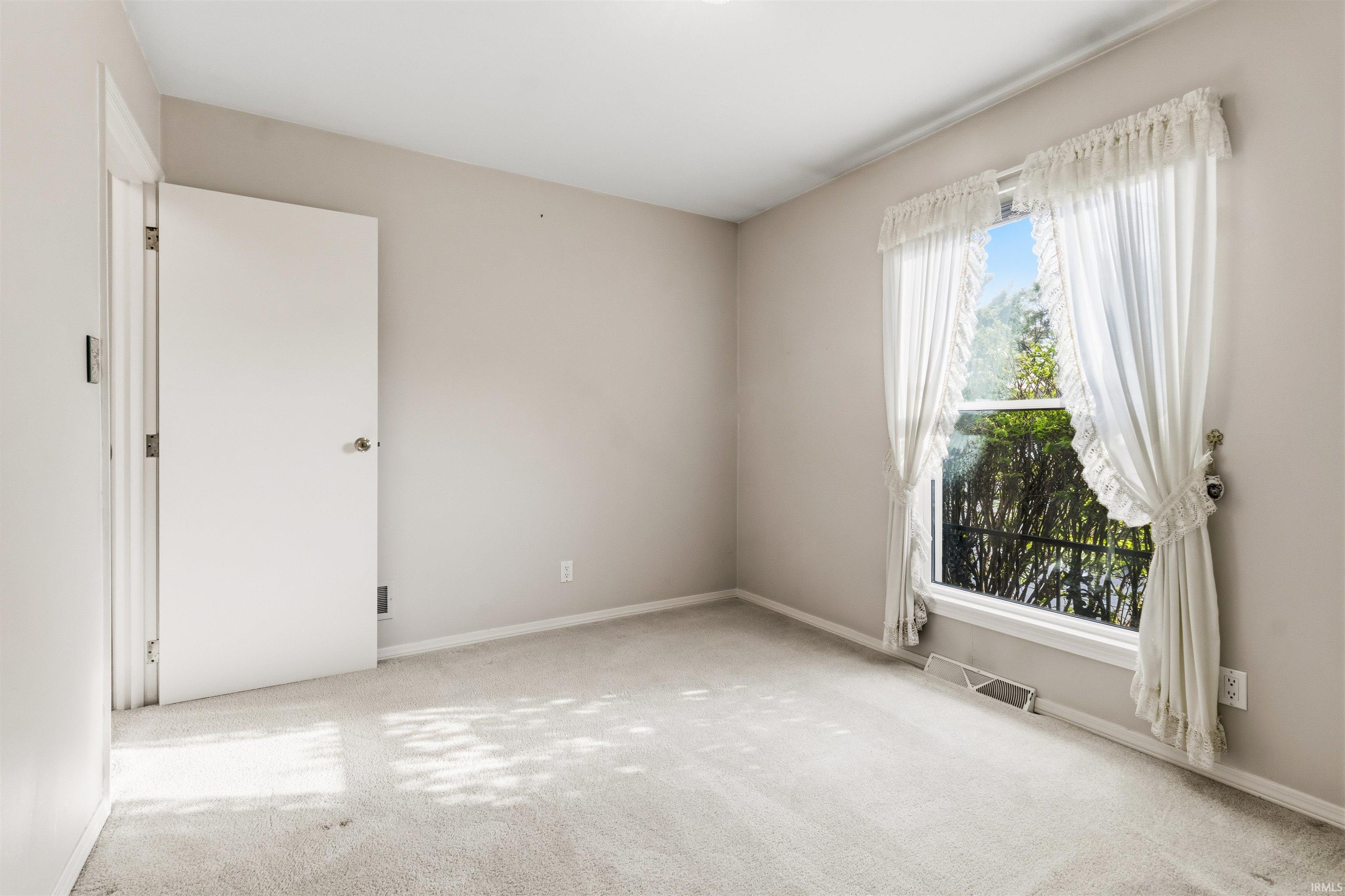 Neutral-toned walls and light-colored carpeting create a bright interior space