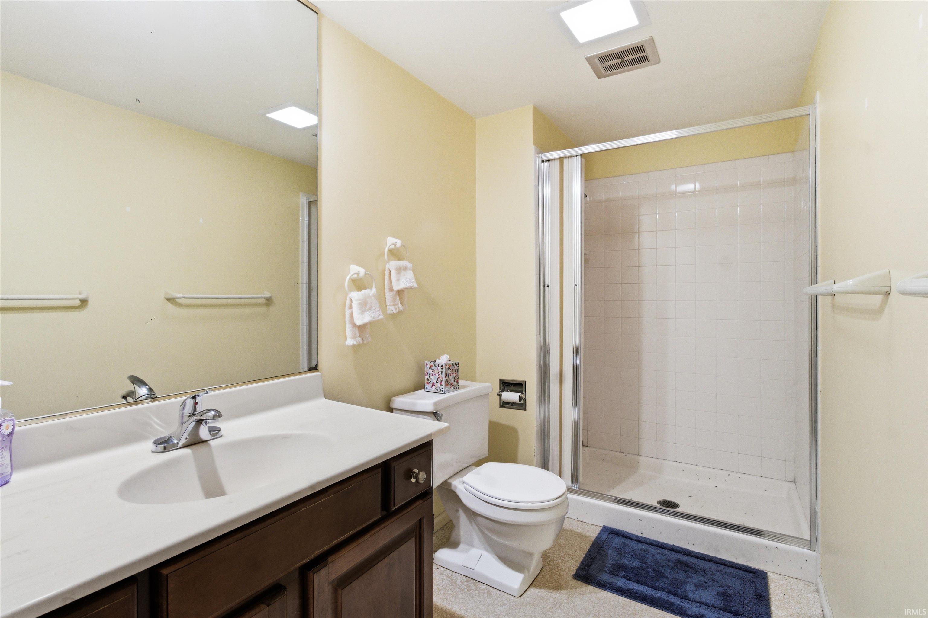Bathroom featuring a shower stall with clear glass doors and white tiled walls