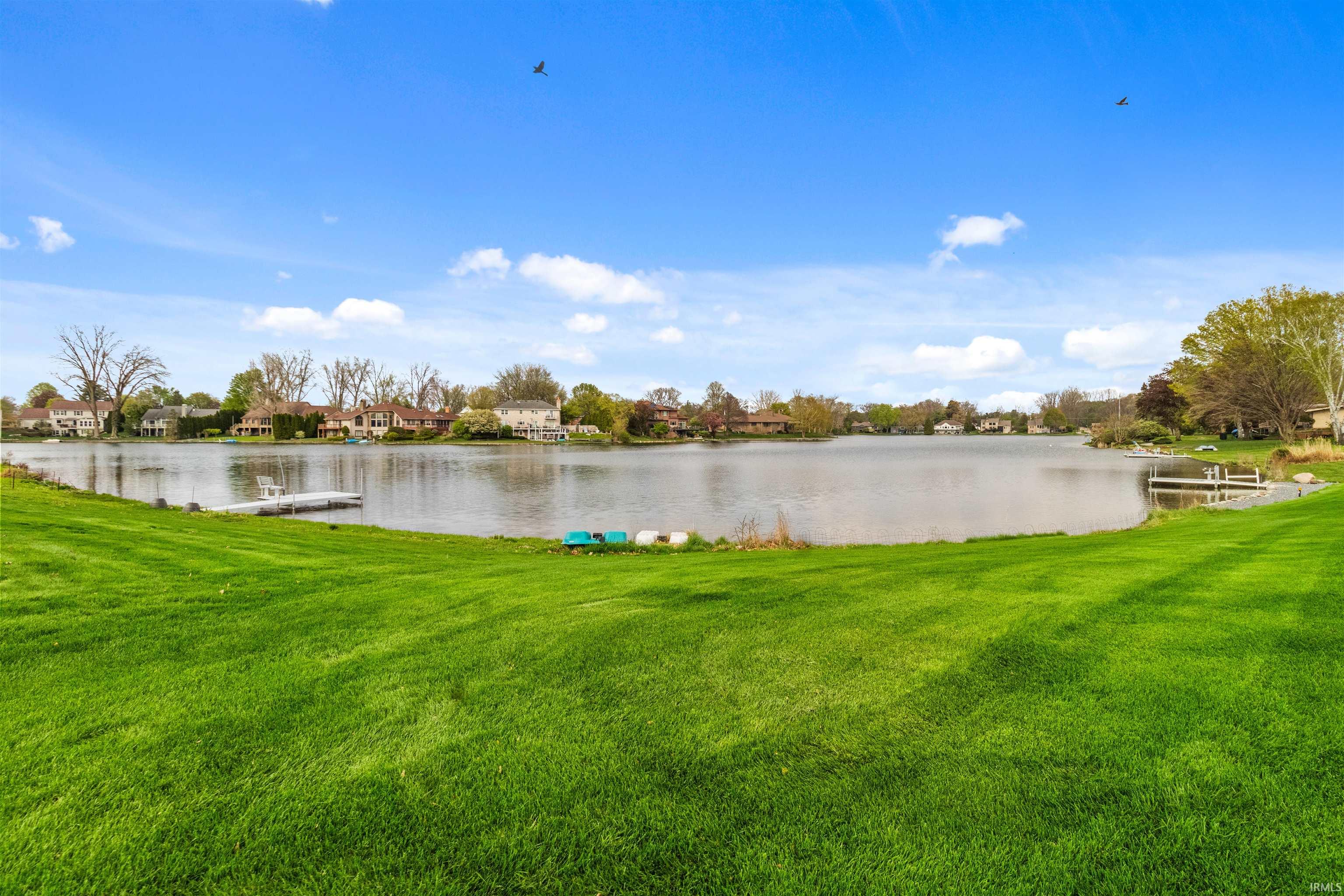 Expansive waterfront lawn with a private dock