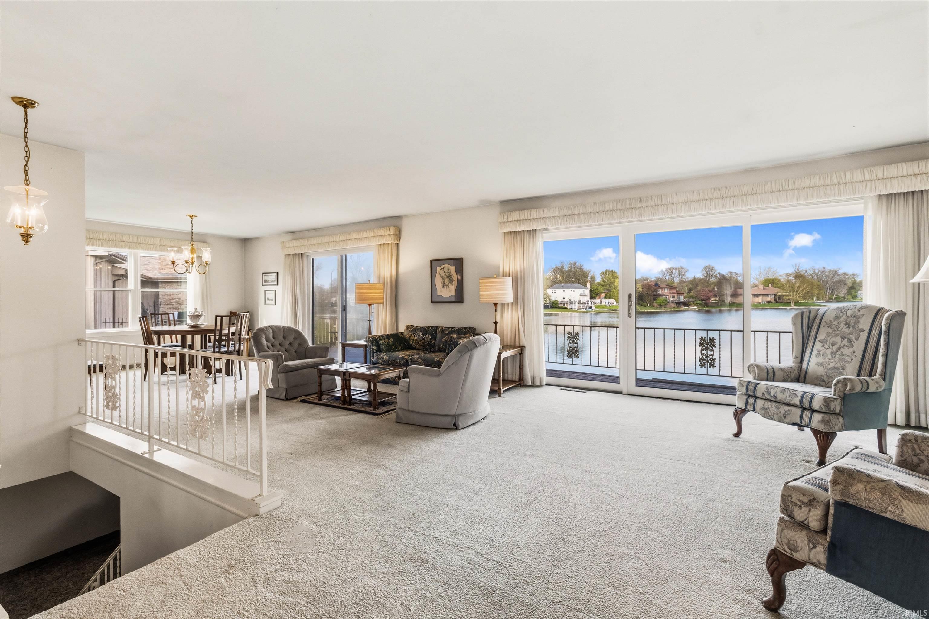 Spacious living area featuring expansive glass sliding doors opening to a scenic waterfront