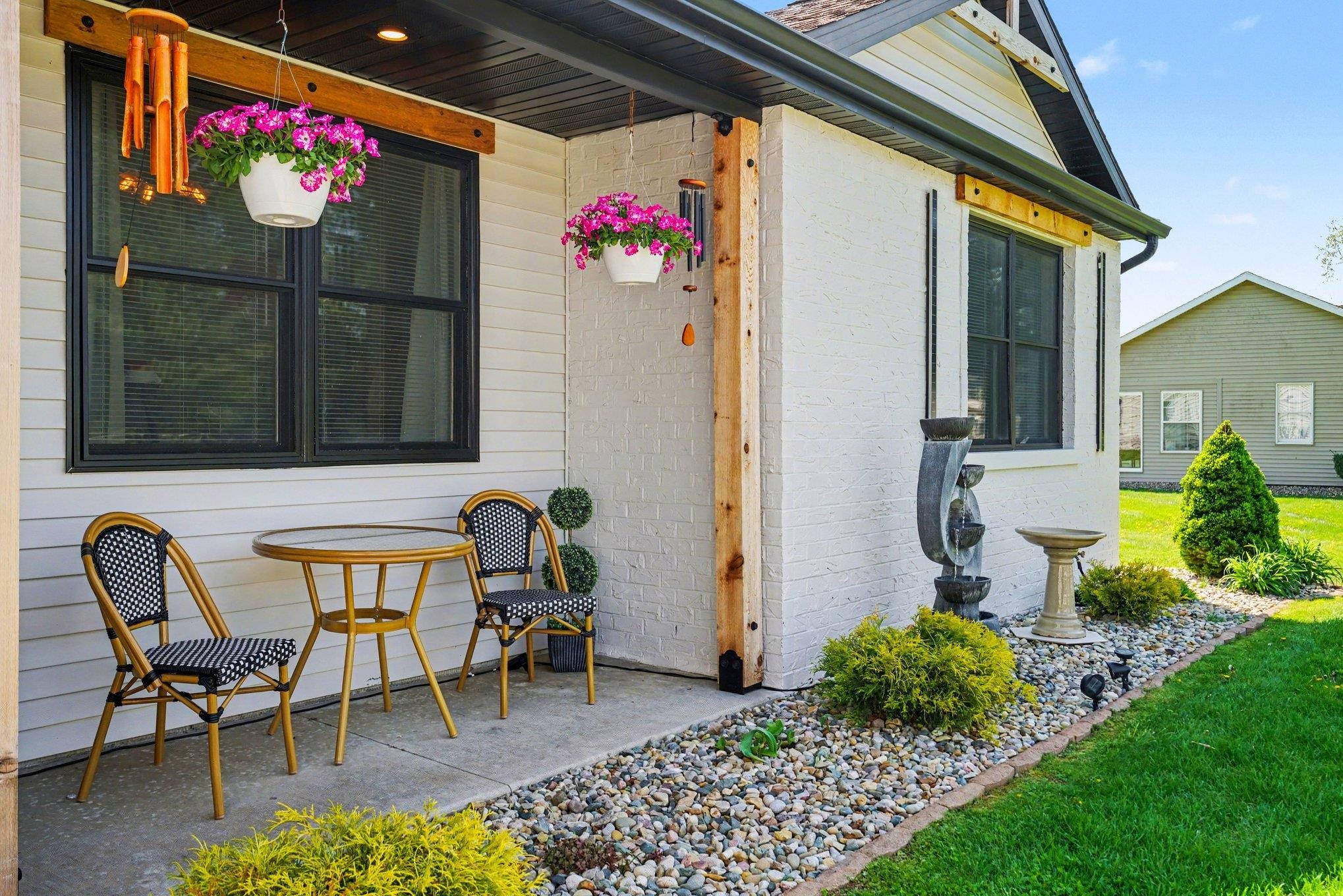 Outdoor patio with a concrete surface, black-framed window, and a white siding exterior
