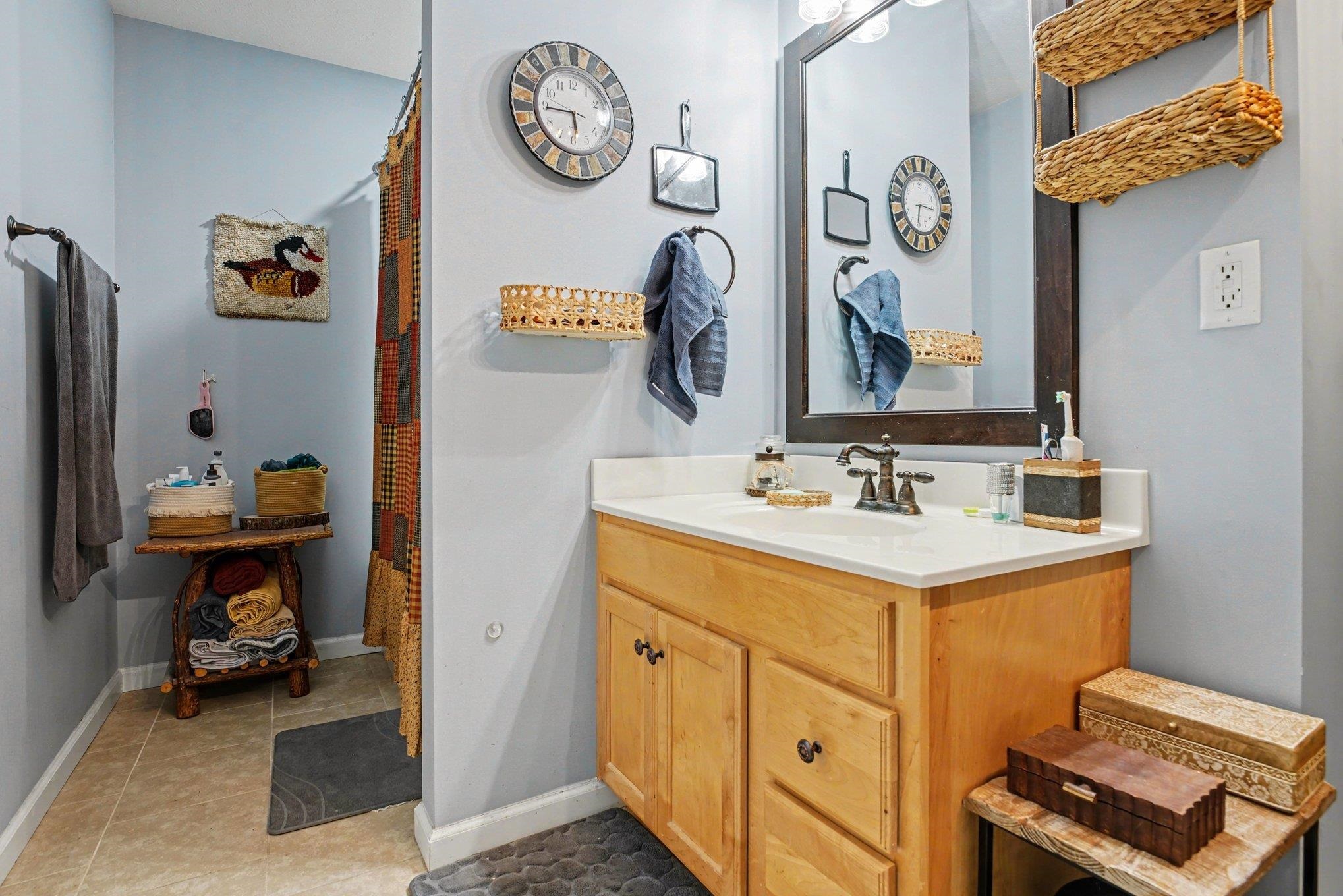 Bathroom featuring a wood-finish vanity with a white countertop and bronze-finish faucet
