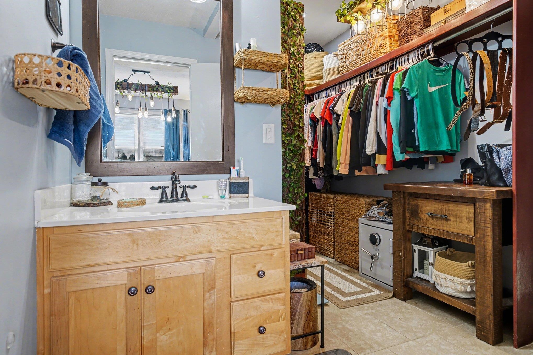 Light wood-finish vanity with a white countertop and dark-toned framed mirror