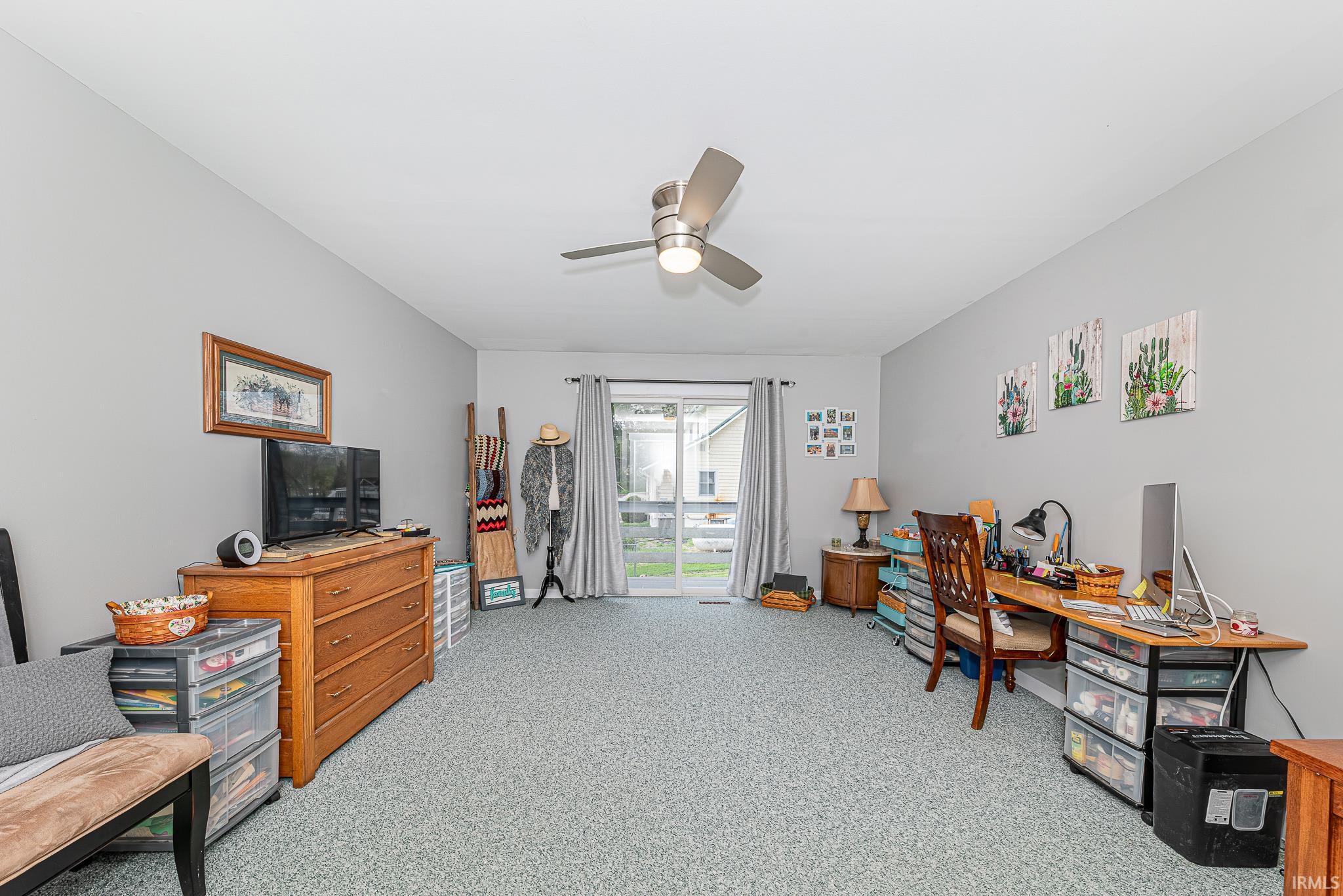 Spacious interior room featuring light gray walls and patterned carpeting