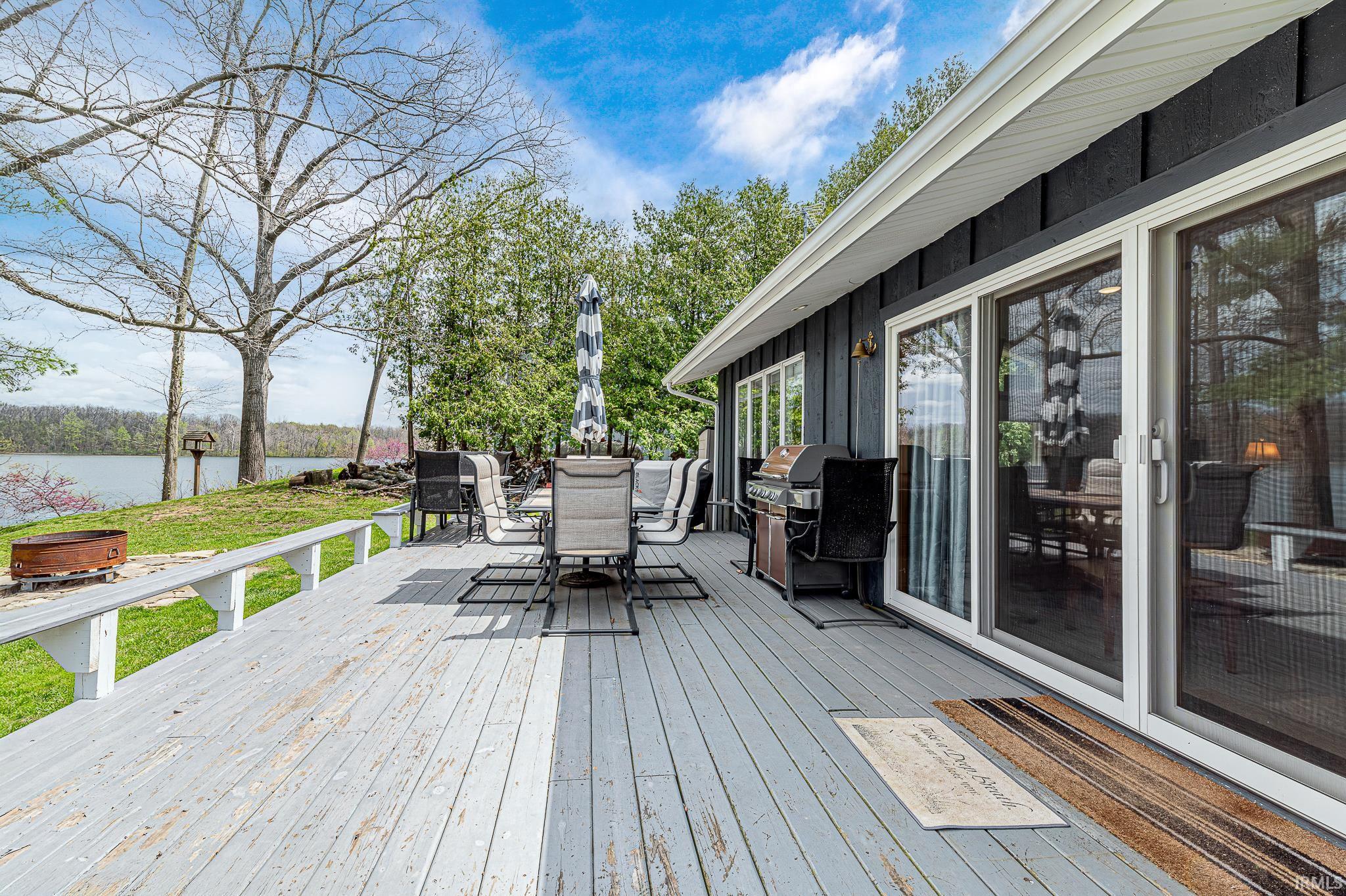 Spacious outdoor deck with a painted wood surface, featuring a built-in bench railing