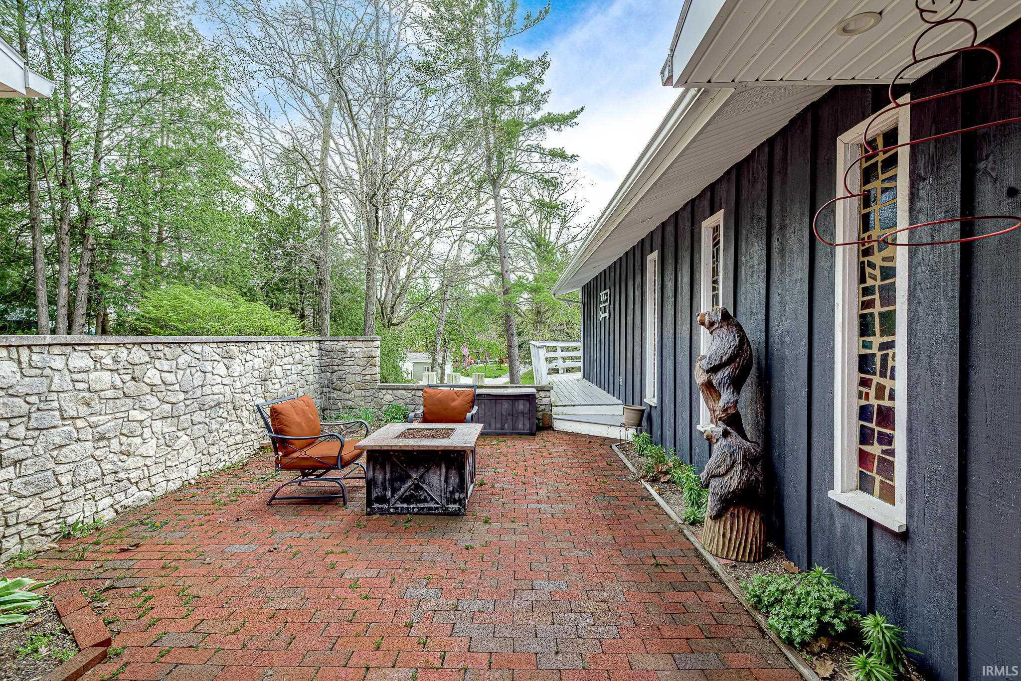 Red brick patio with a stacked stone wall
