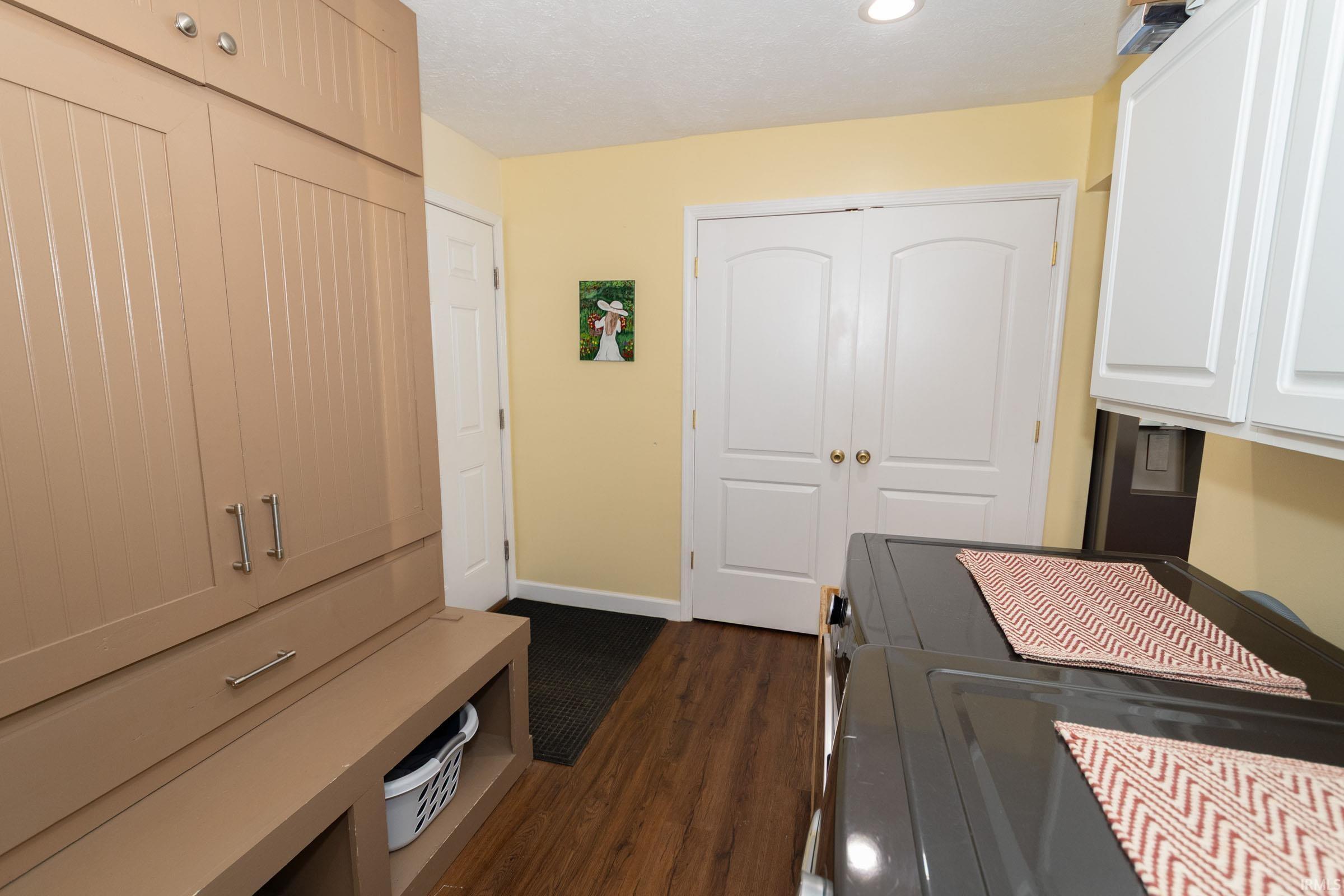 Built-in cabinetry with beadboard paneling, integrated bench seating, and overhead storage